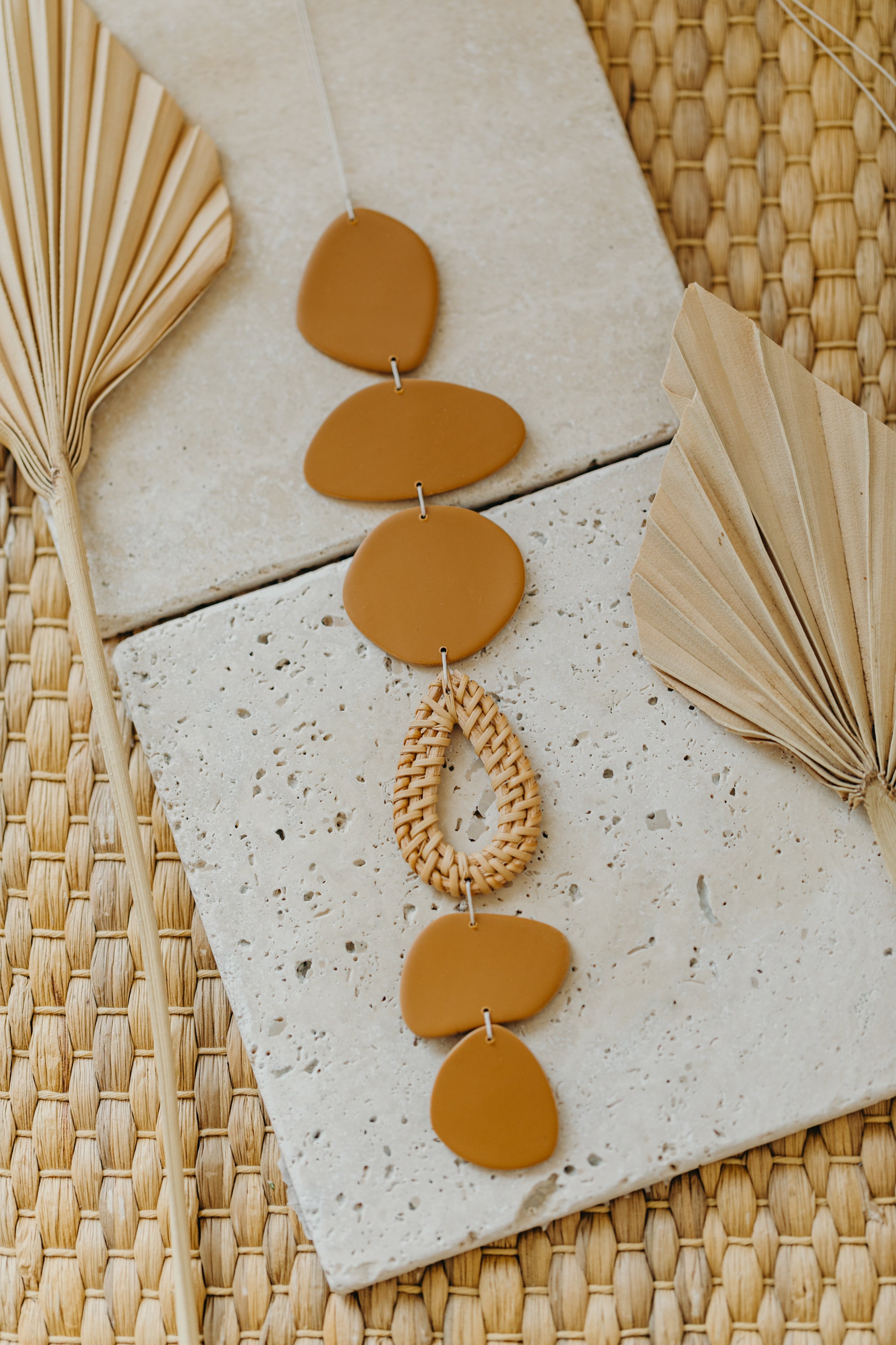 Wall mobile made of polymer clay in natural colors and rattan elements