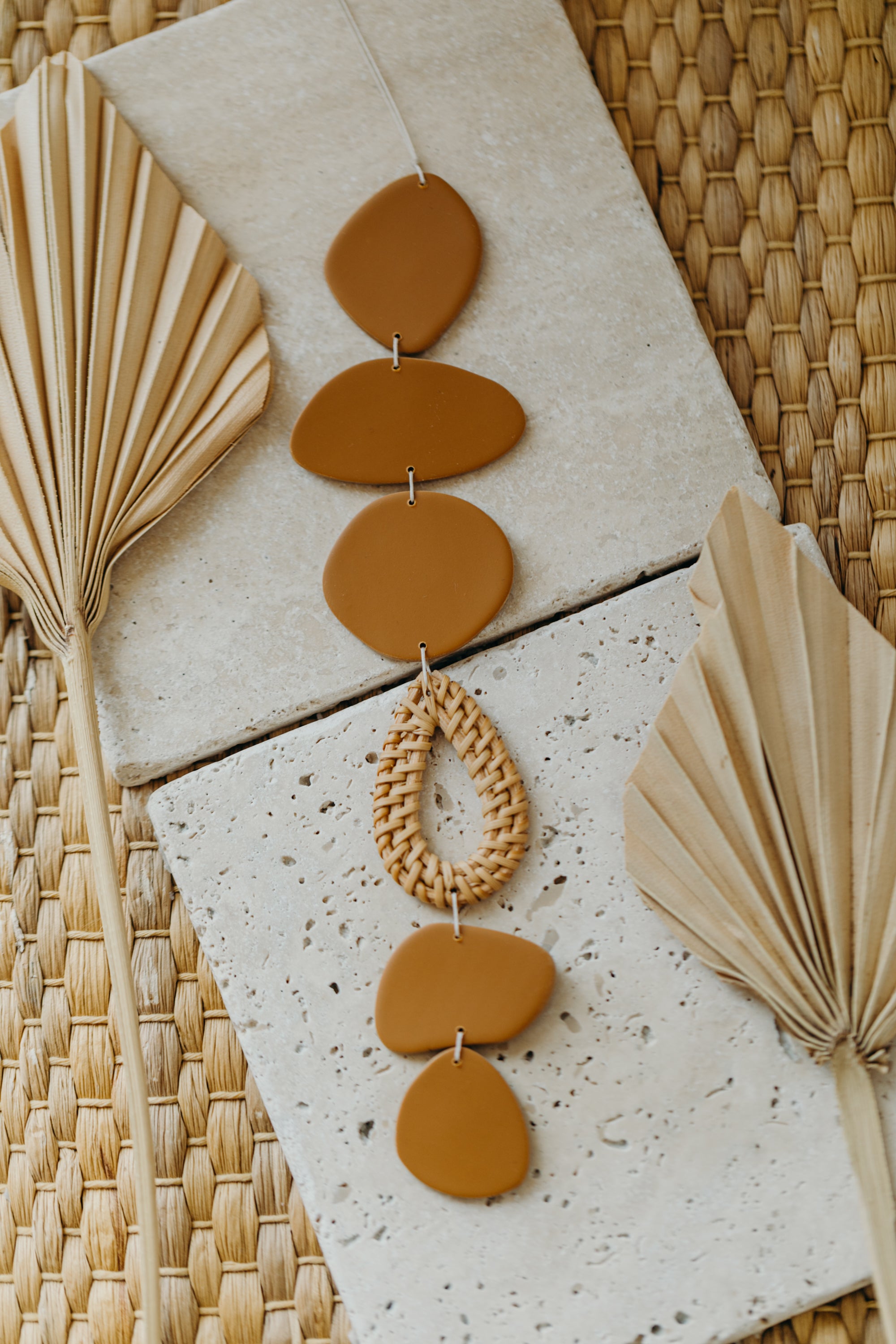 Wall mobile made of polymer clay in natural colors and rattan elements
