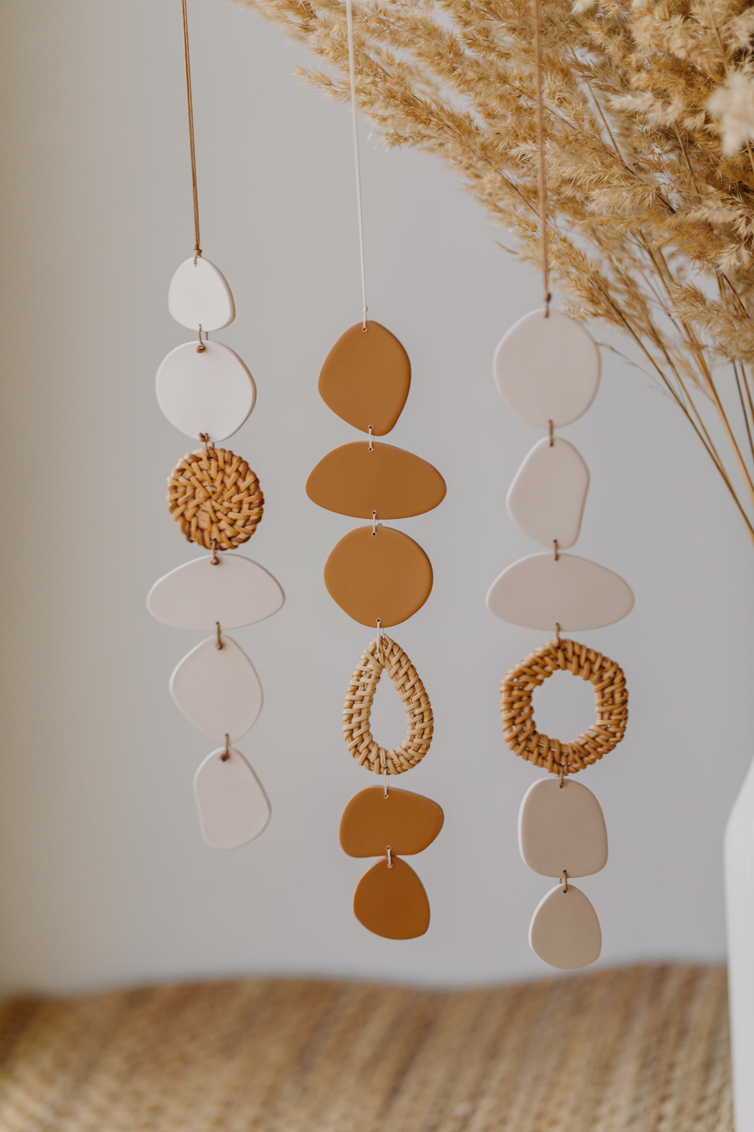 Wand Mobile aus Polymer Ton in der Farbe Creme mit Rattan Elementen