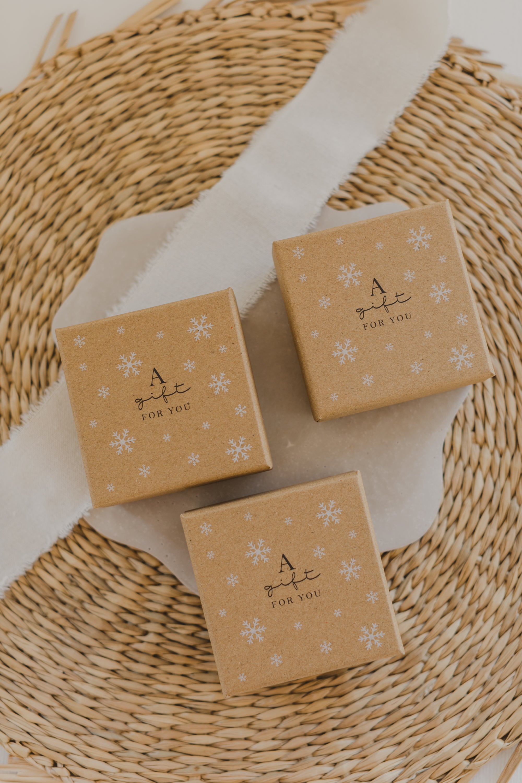 Gift box kraft paper with print "A gift for you" and white snowflakes