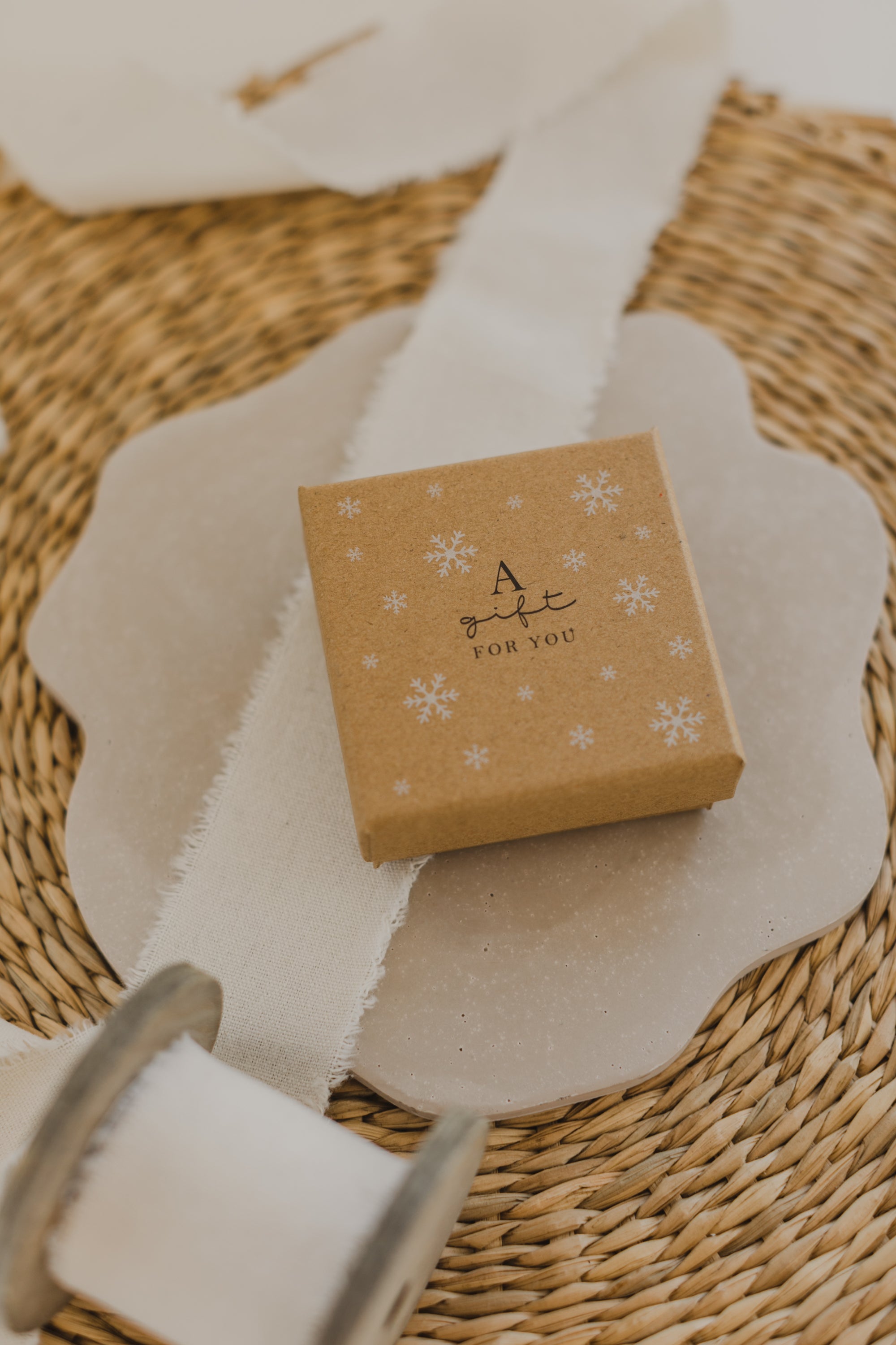 Gift box kraft paper with print "A gift for you" and white snowflakes