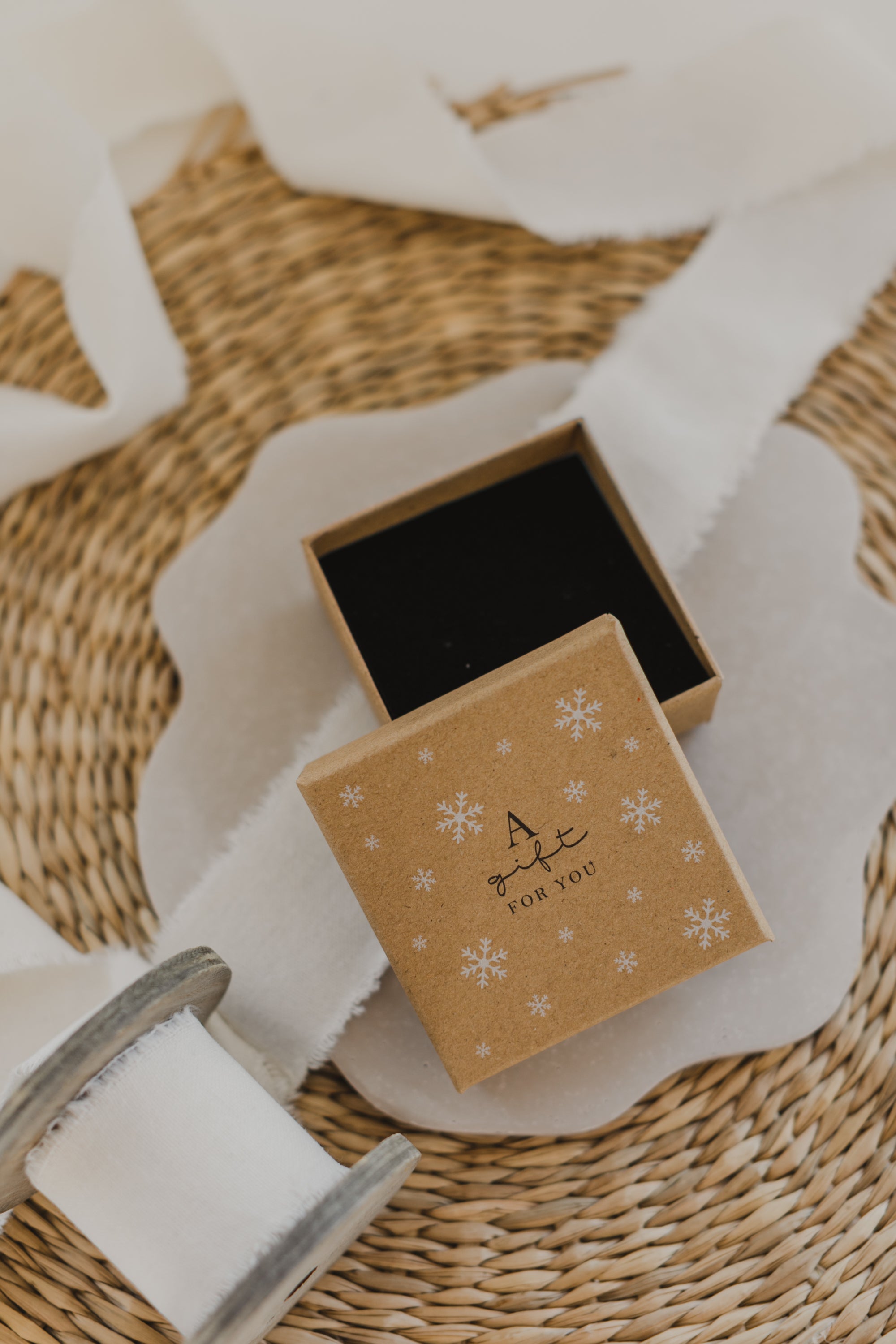 Gift box kraft paper with print "A gift for you" and white snowflakes
