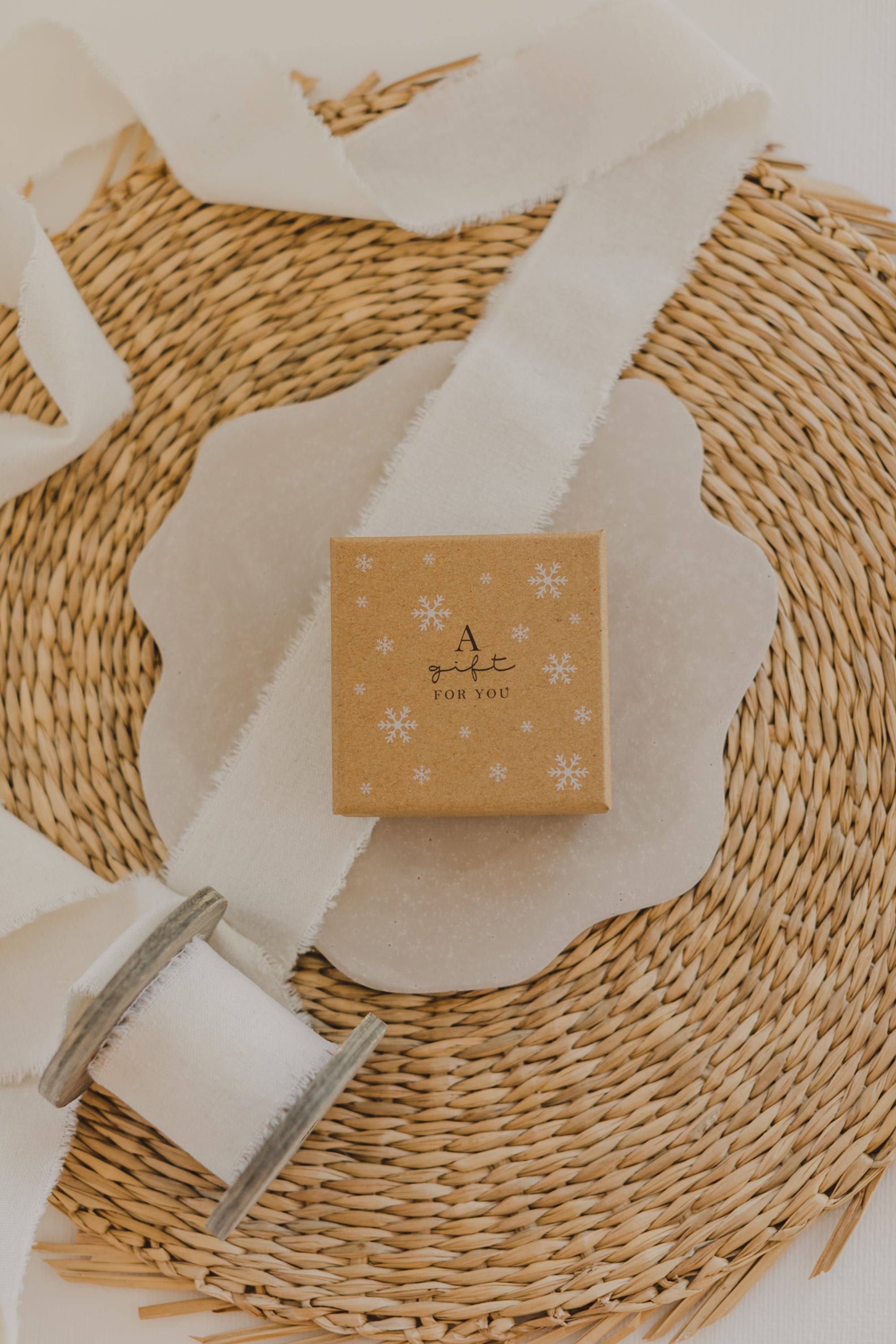 Gift box kraft paper with print "A gift for you" and white snowflakes