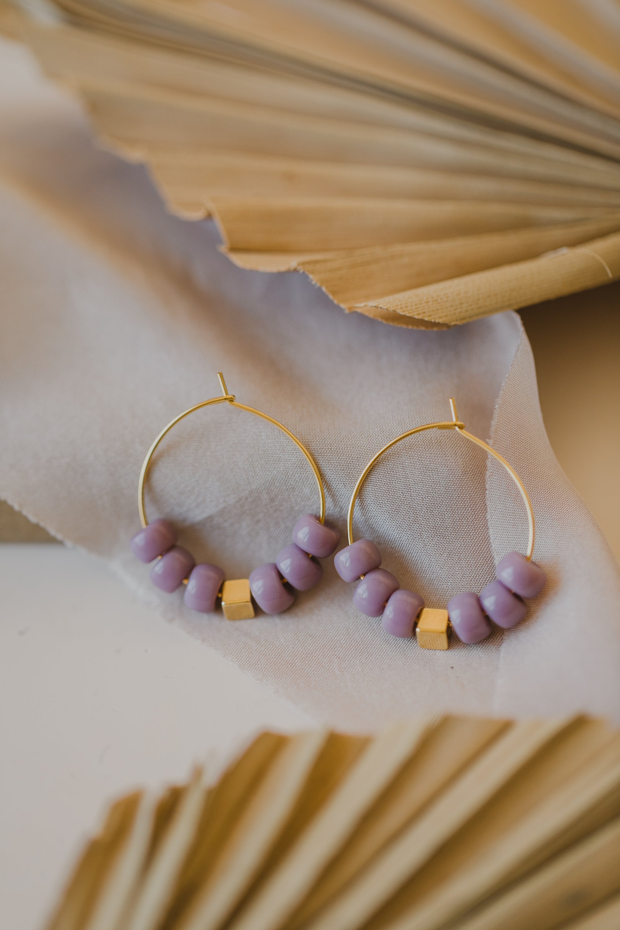 filigree creole made of titanium with purple ceramic beads