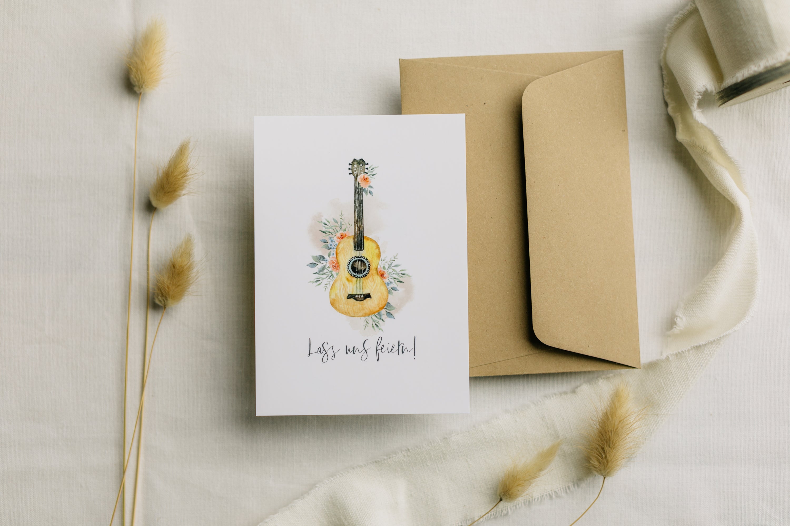 Postkarte Gitarre mit Blumen mit dem Aufdruck "Lass uns feiern"