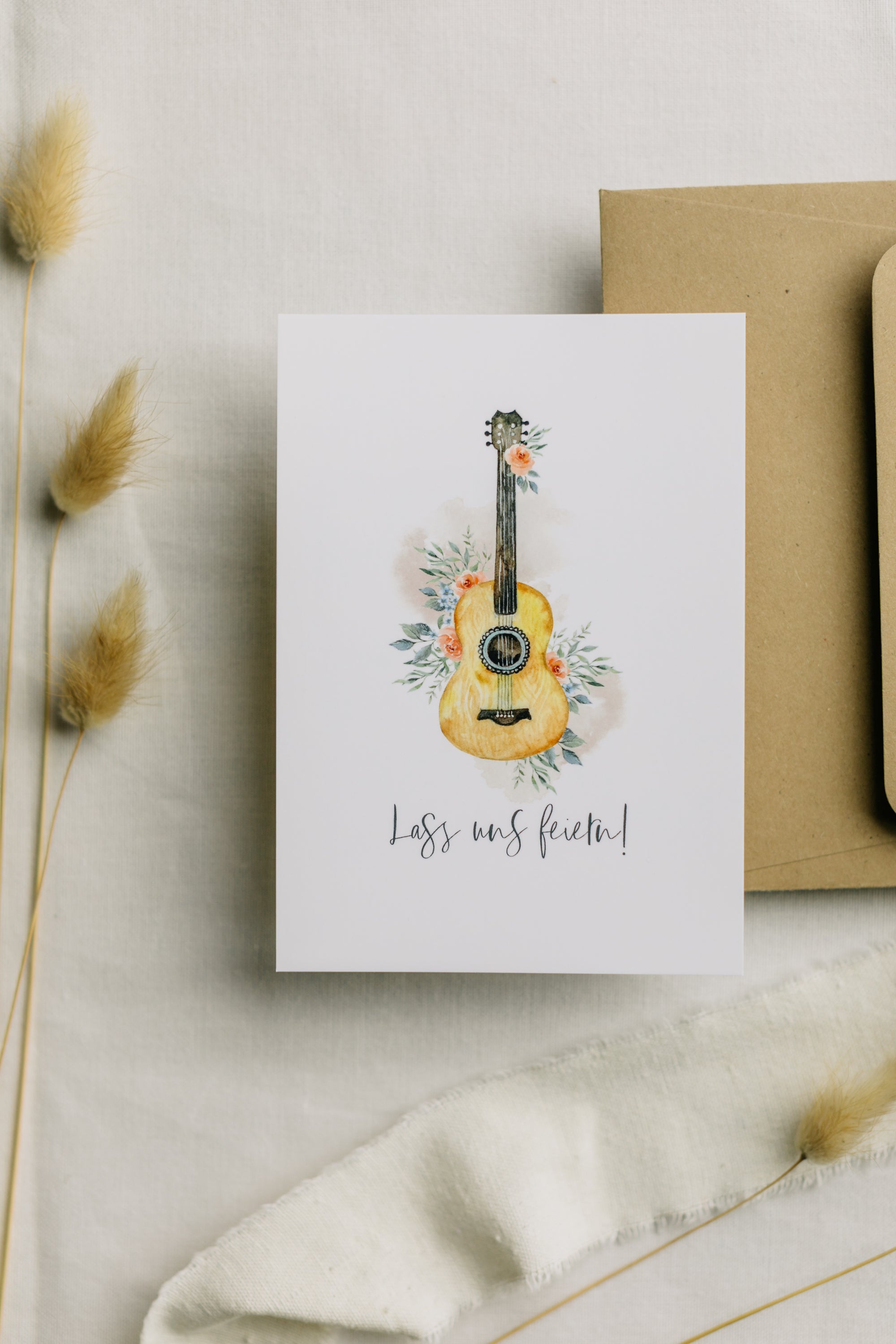 Postkarte Gitarre mit Blumen mit dem Aufdruck "Lass uns feiern"