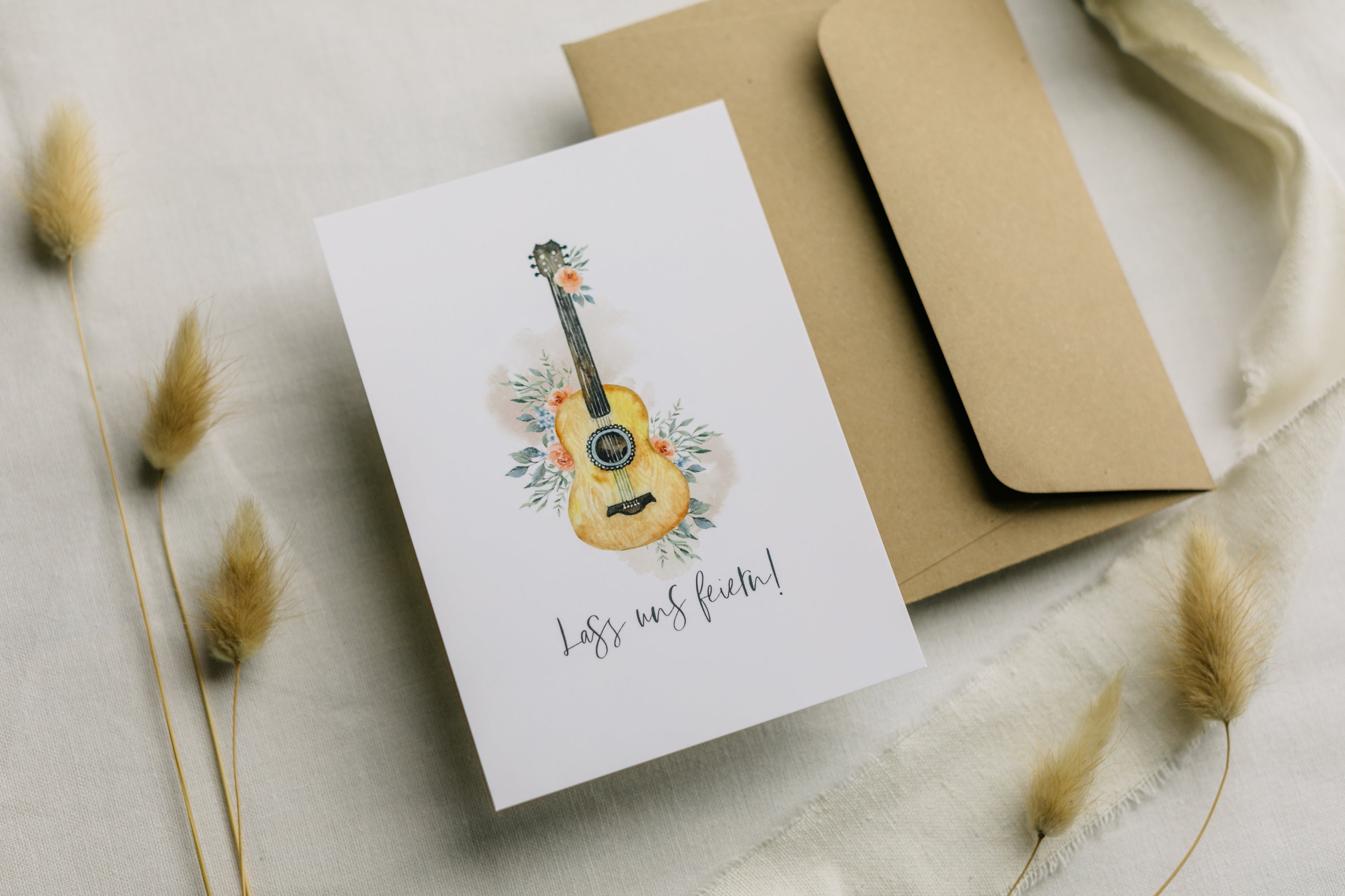 Postkarte Gitarre mit Blumen mit dem Aufdruck "Lass uns feiern"