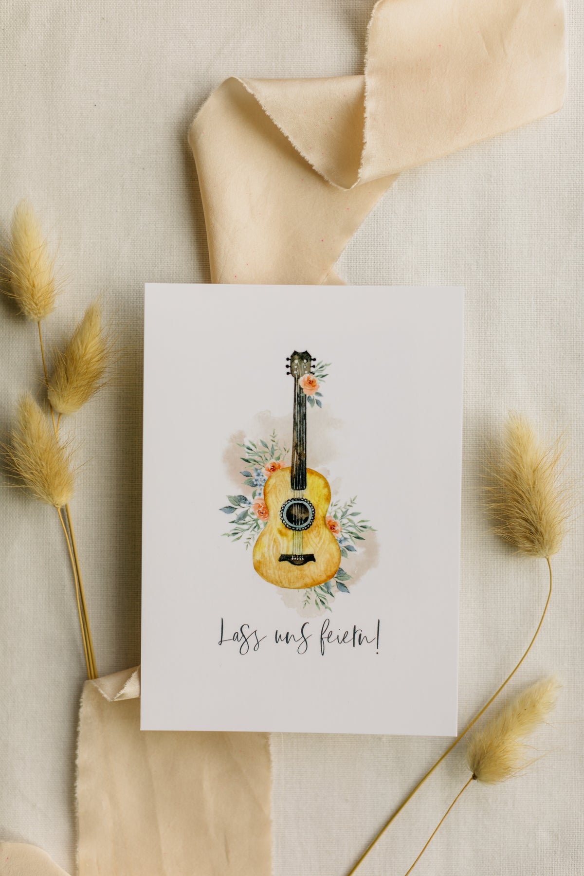 Postkarte Gitarre mit Blumen mit dem Aufdruck "Lass uns feiern"