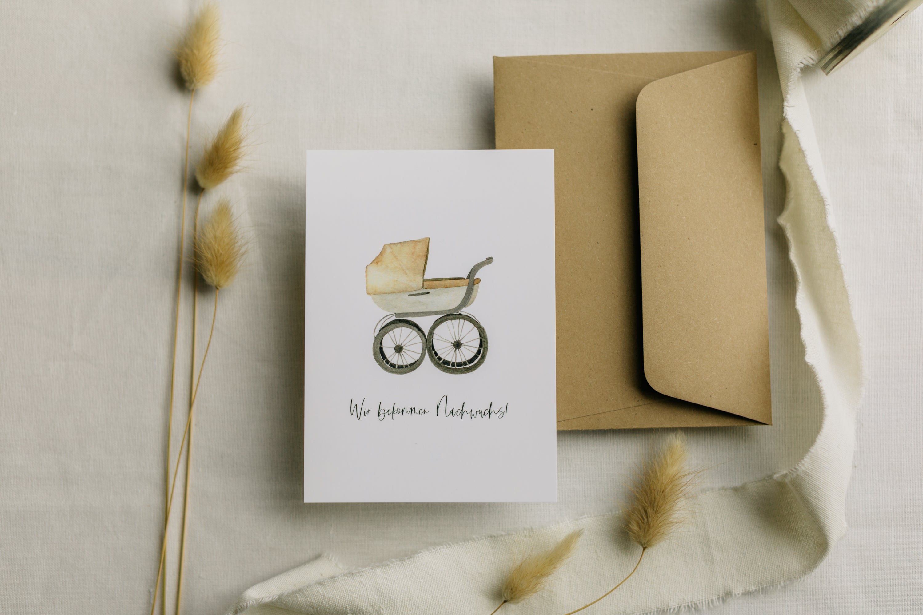 Postkarte Kinderwagen mit dem Aufdruck "Wir bekommen Nachwuchs"