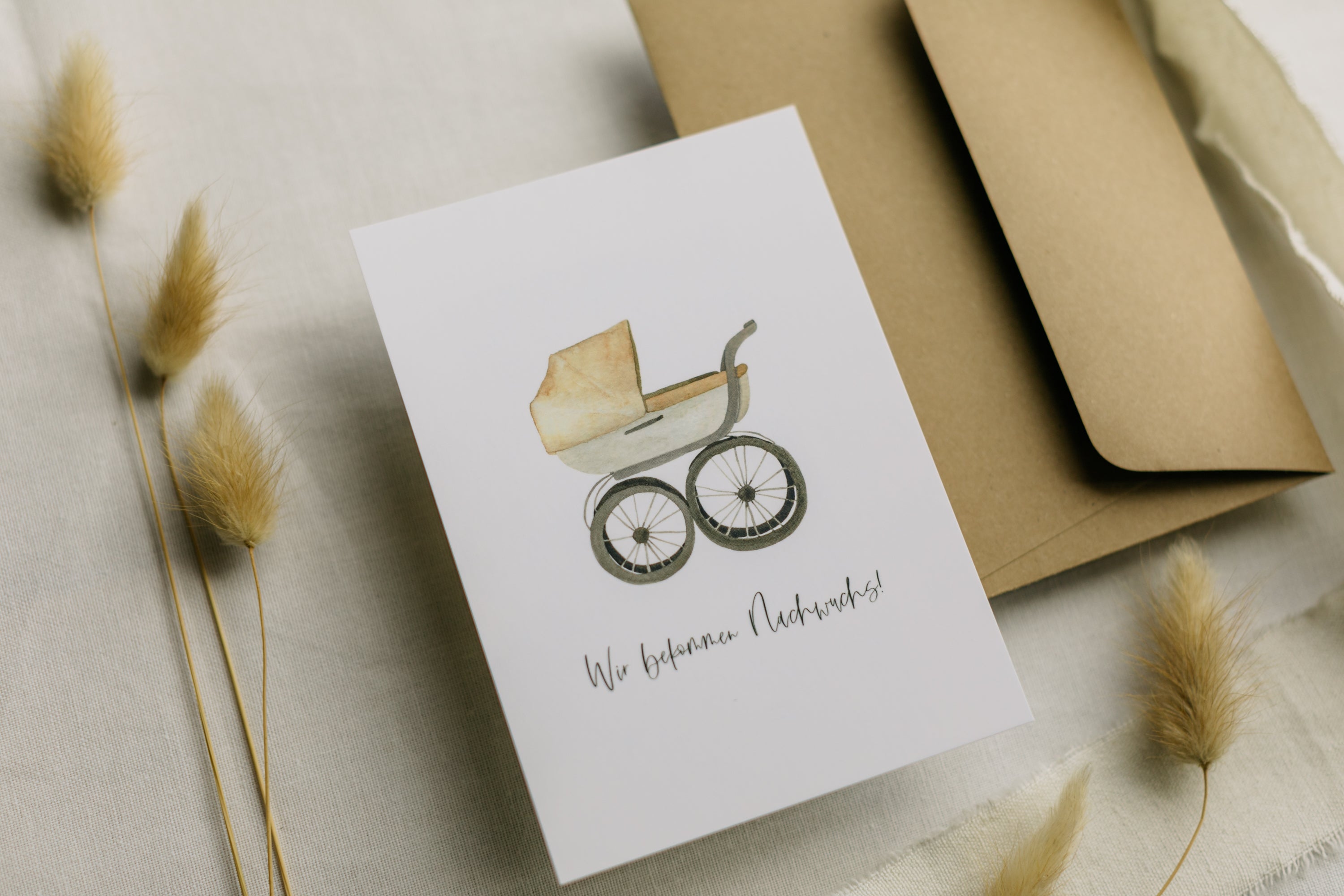 Postkarte Kinderwagen mit dem Aufdruck "Wir bekommen Nachwuchs"