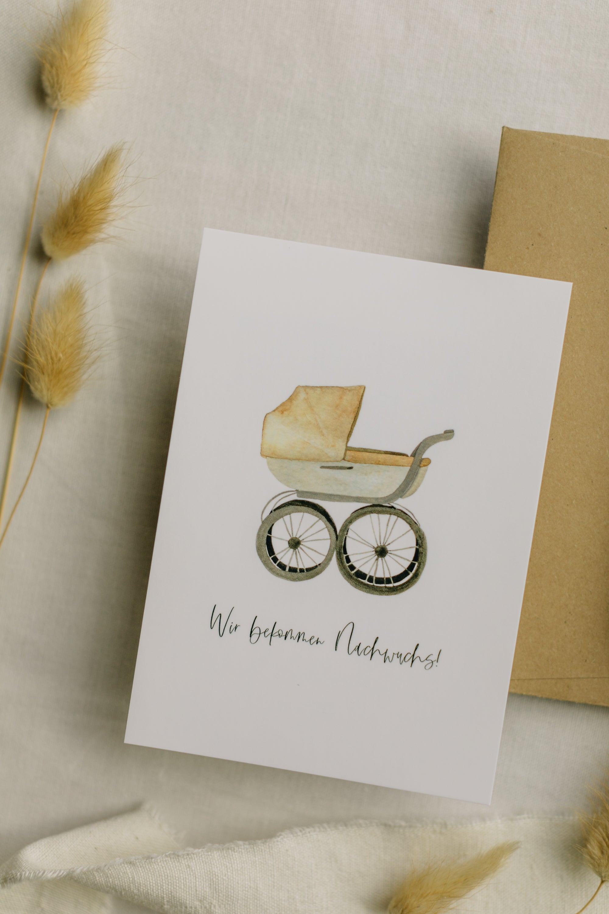 Postkarte Kinderwagen mit dem Aufdruck "Wir bekommen Nachwuchs"