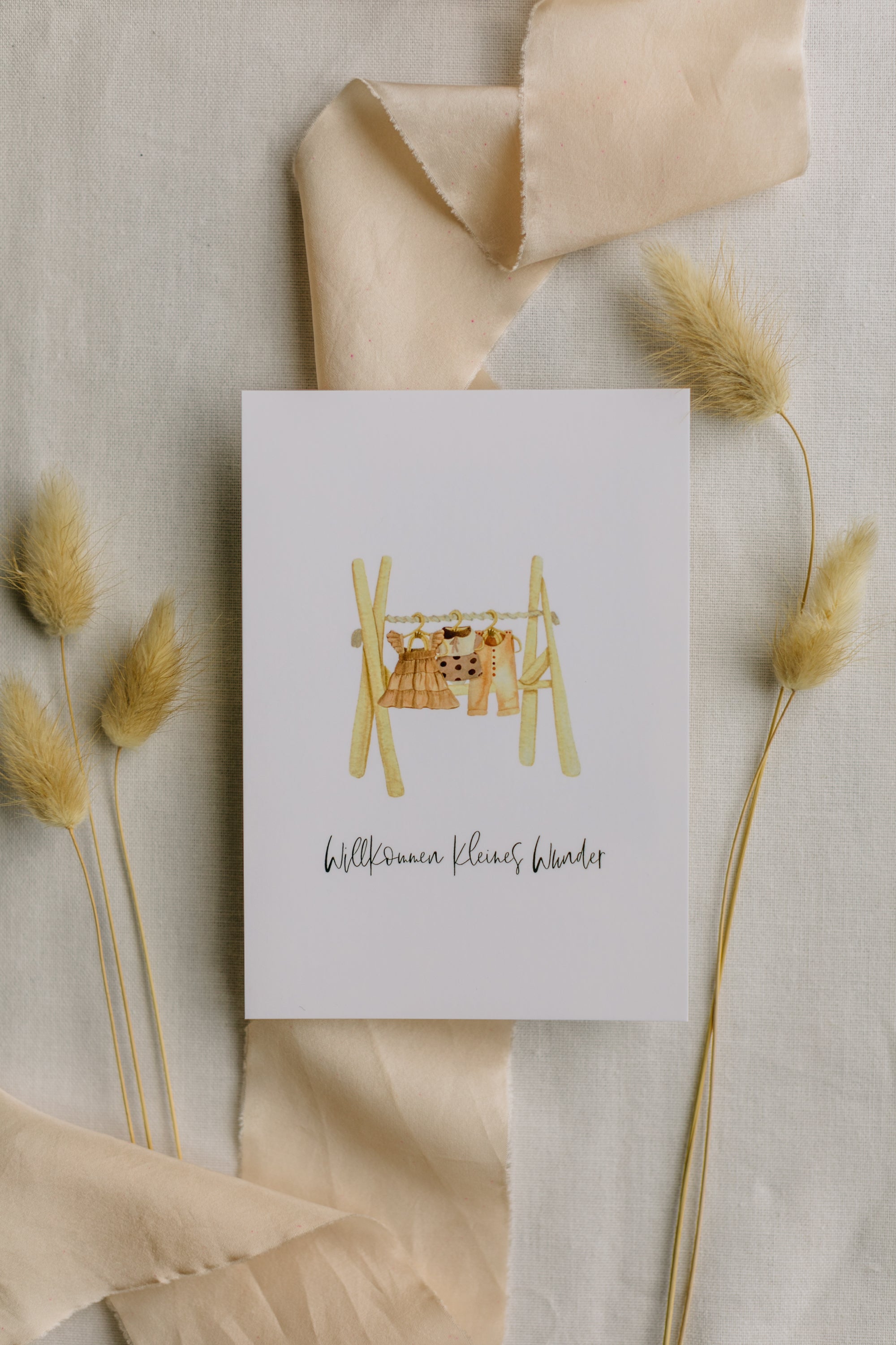 Postcard clothes rack with the print "Welcome little miracle"