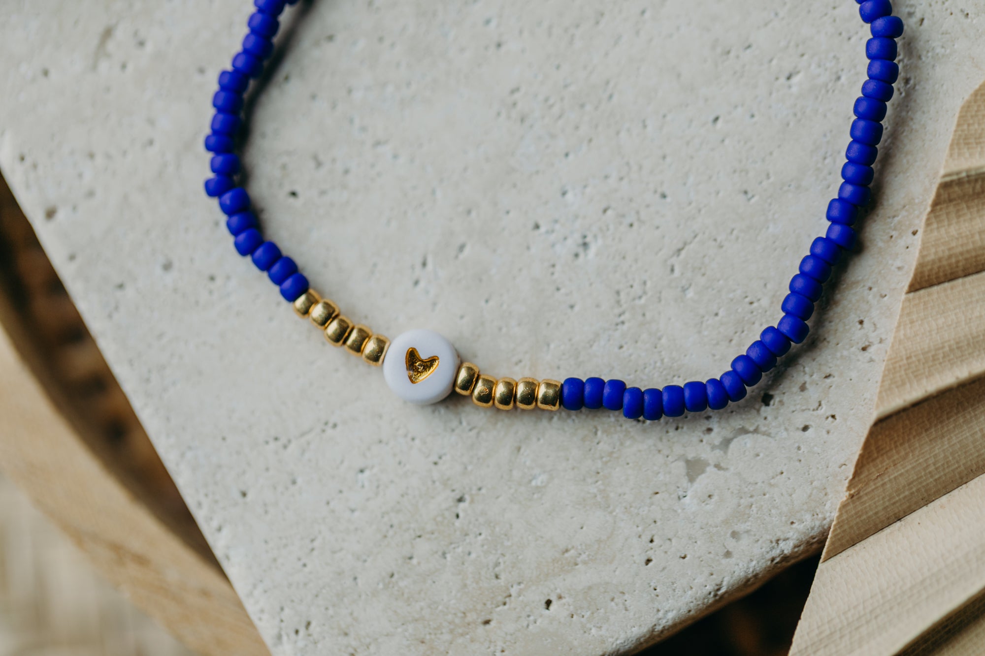 weiß-goldenes Herz Perlenarmband in kornblumenblau