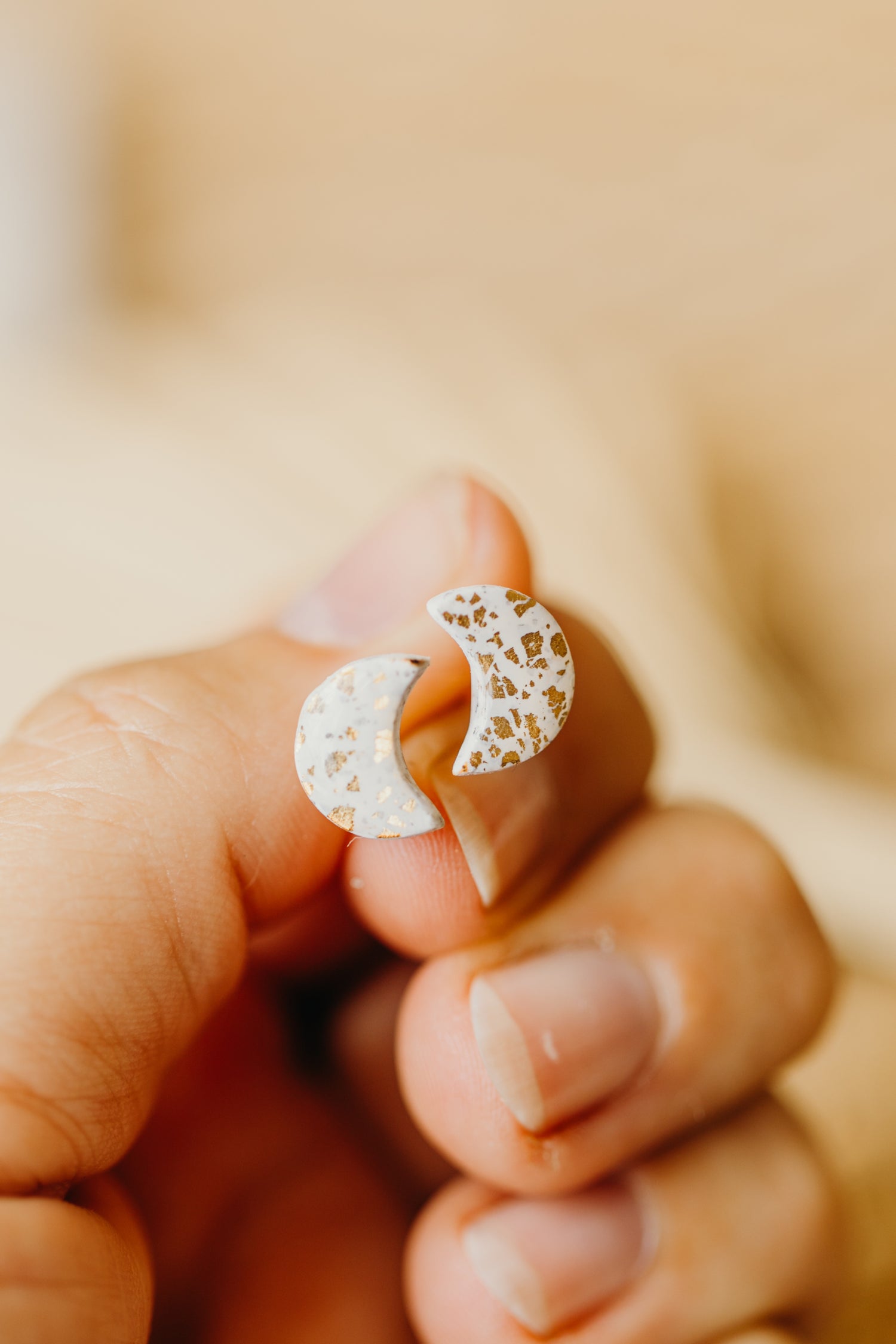 small moon earrings made of polymer clay with gold leaf