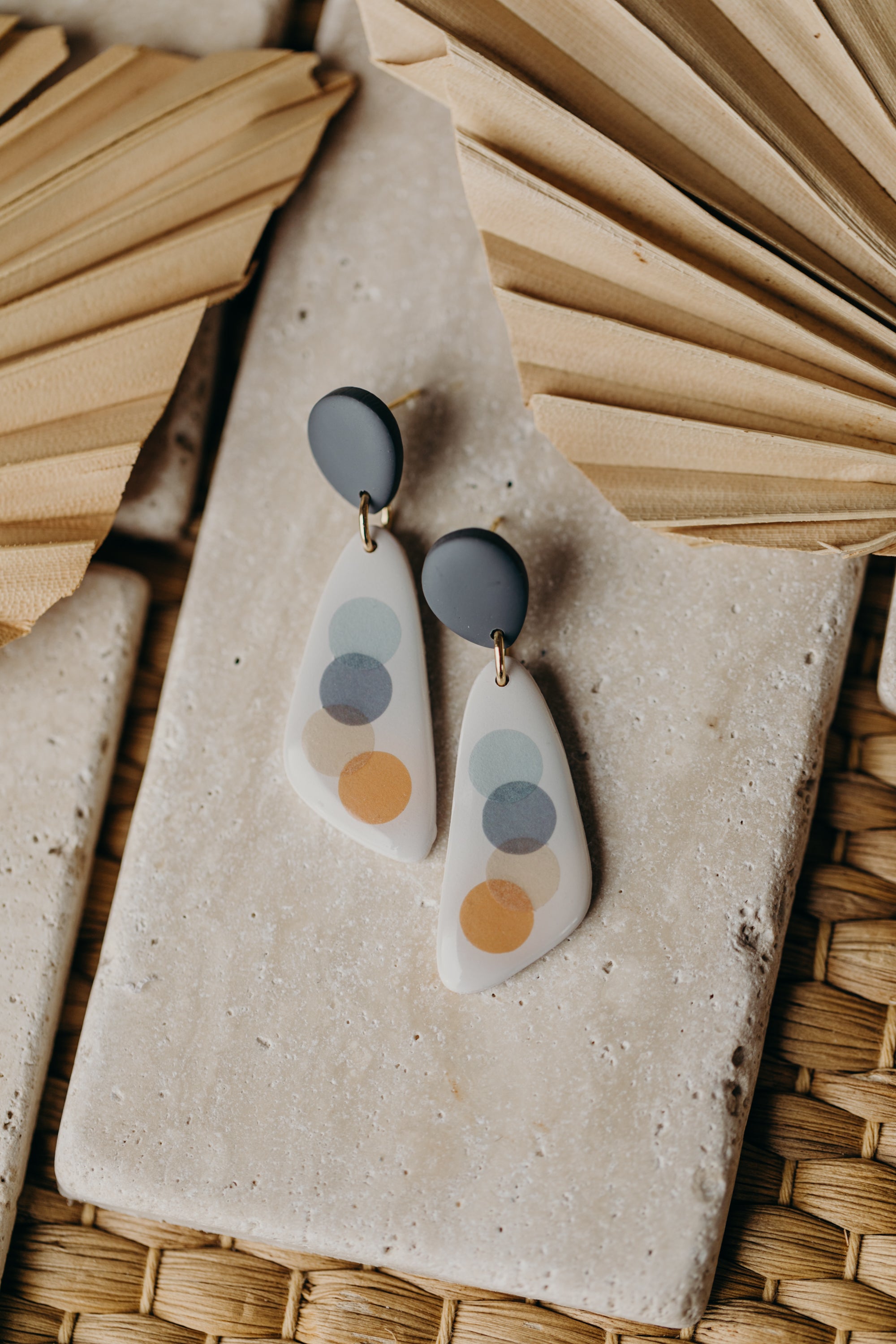 elongated blue-grey polymer clay earrings with blue and orange dots