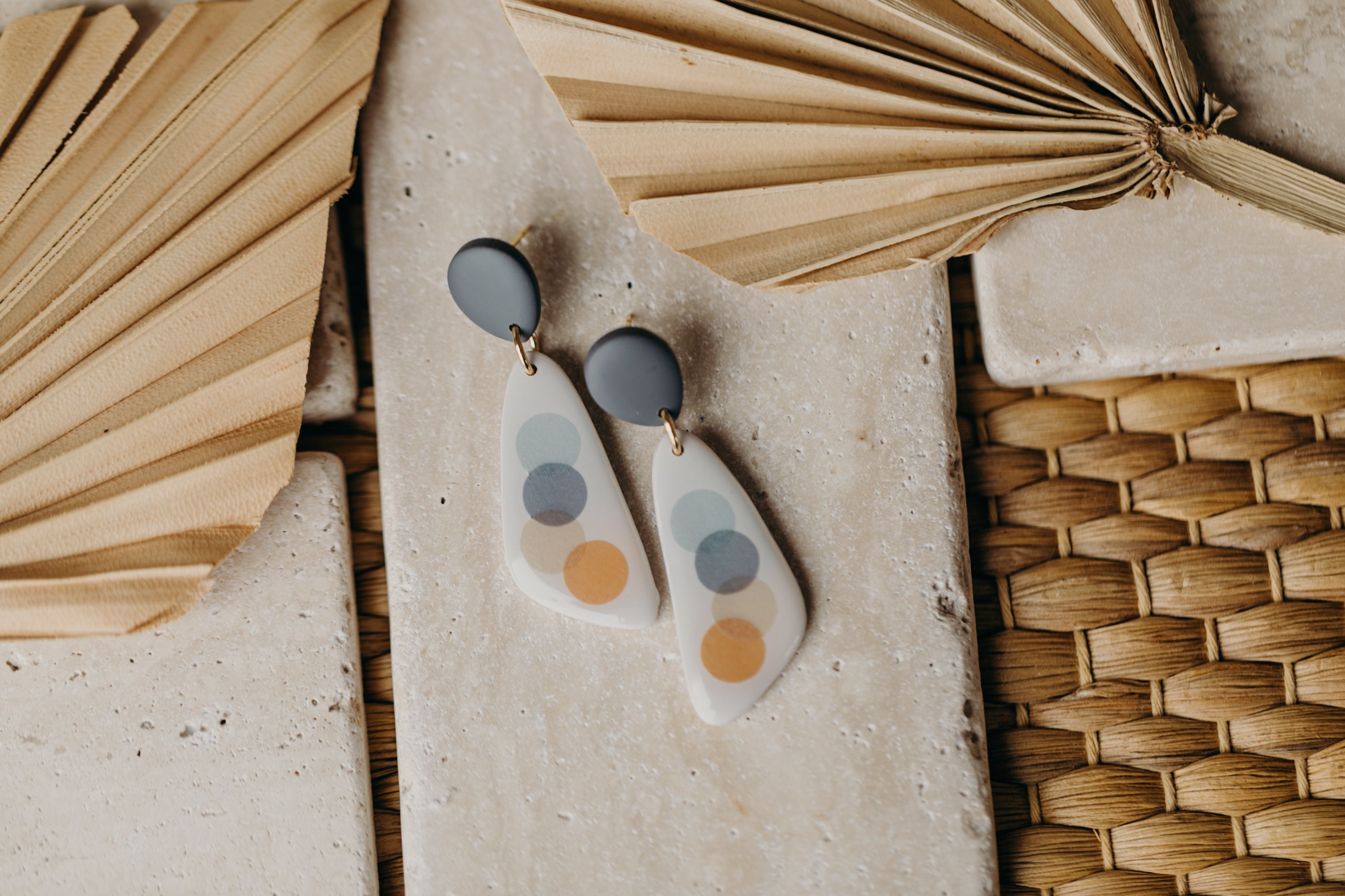 elongated blue-grey polymer clay earrings with blue and orange dots