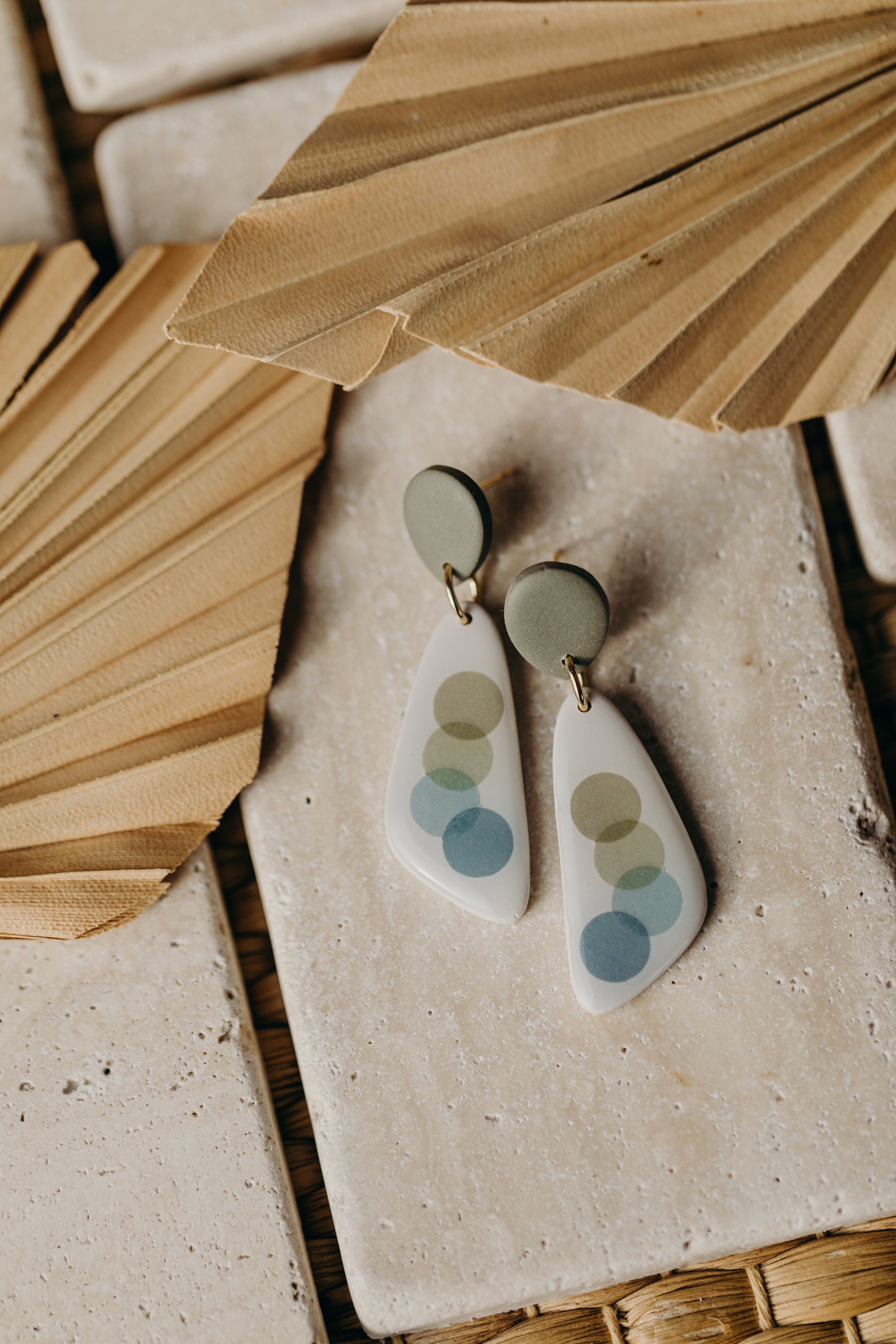 elongated green polymer clay earrings with blue and green dots