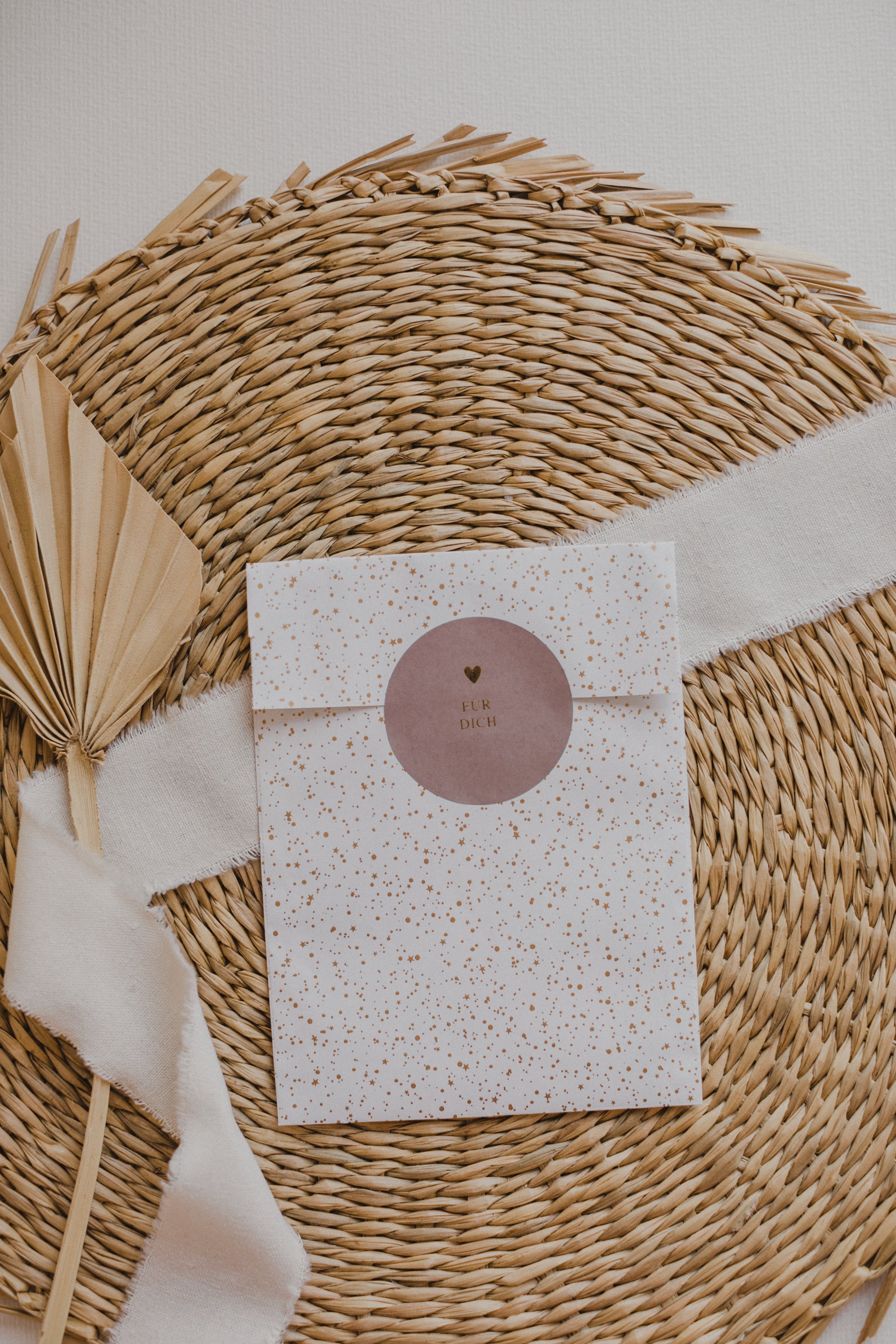 große weiße Papiertüte mit goldenen Punkten