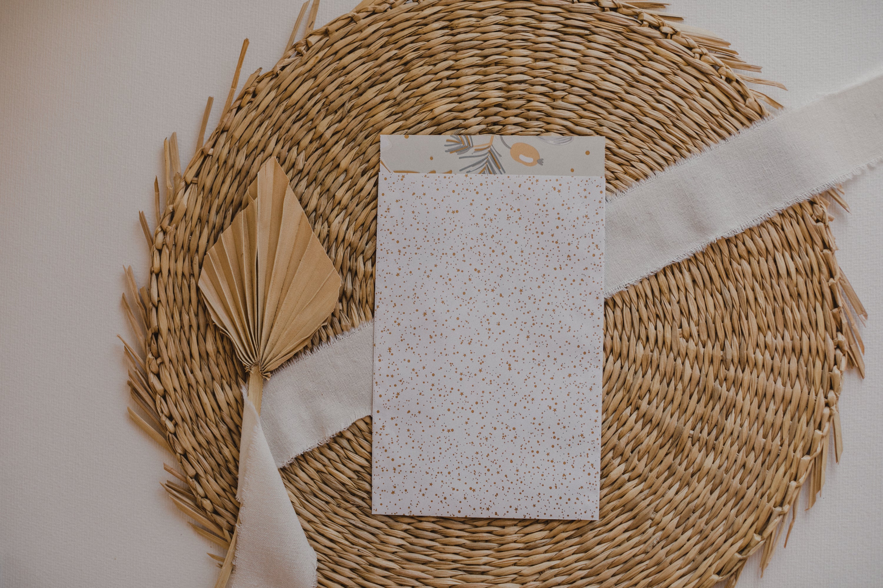 große weiße Papiertüte mit goldenen Punkten