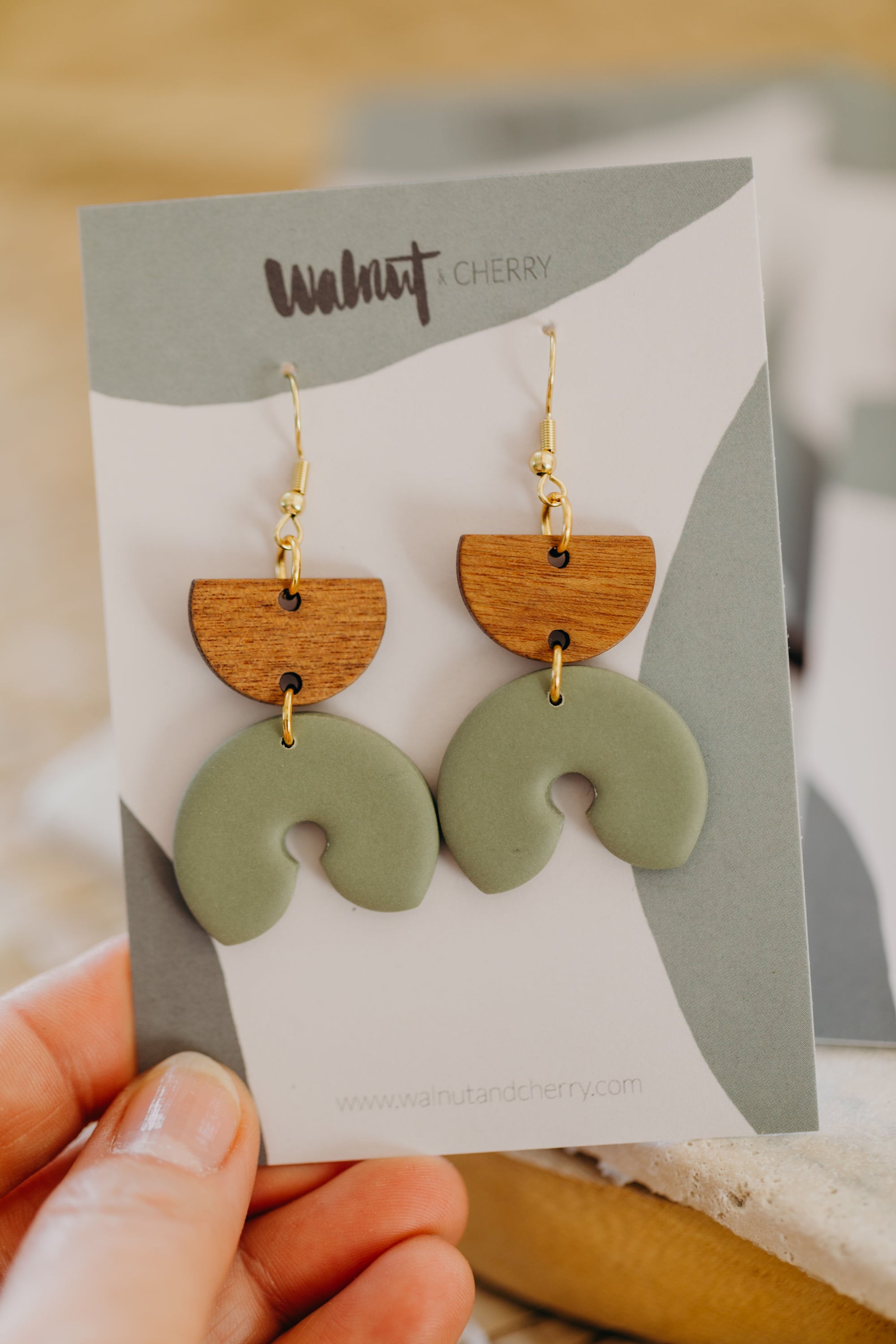 triangular polymer clay earrings in eucalyptus green with rectangular wooden pendant