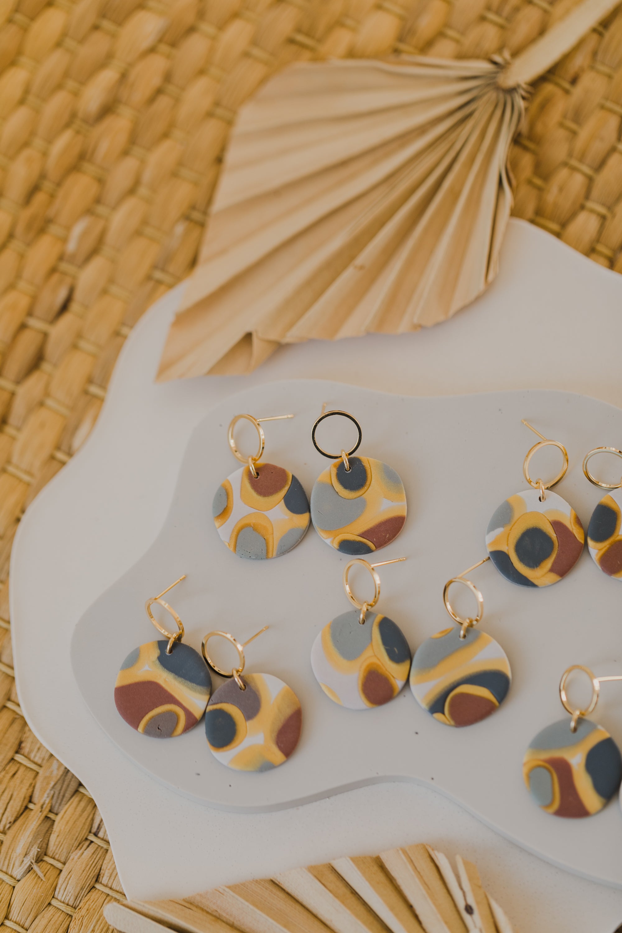golden earrings with acrylic in white, petrol and brown
