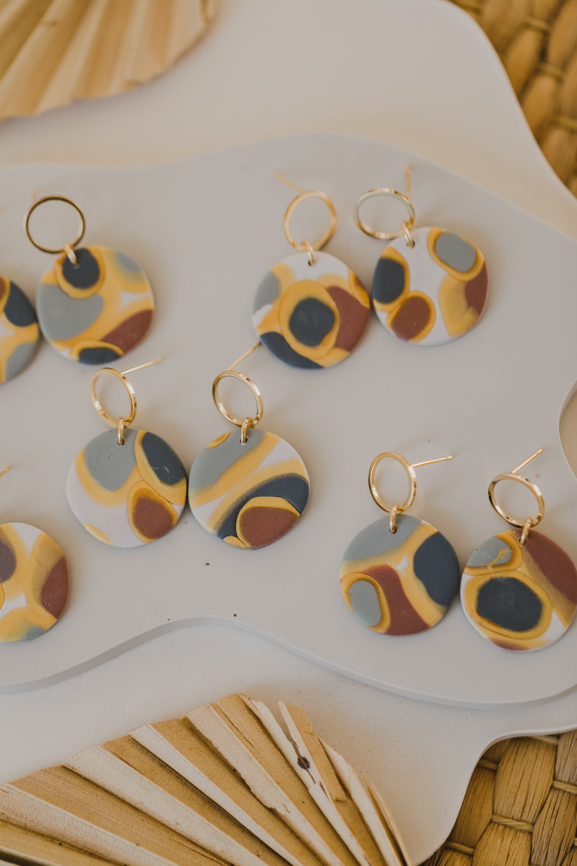 golden earrings with acrylic in white, petrol and brown