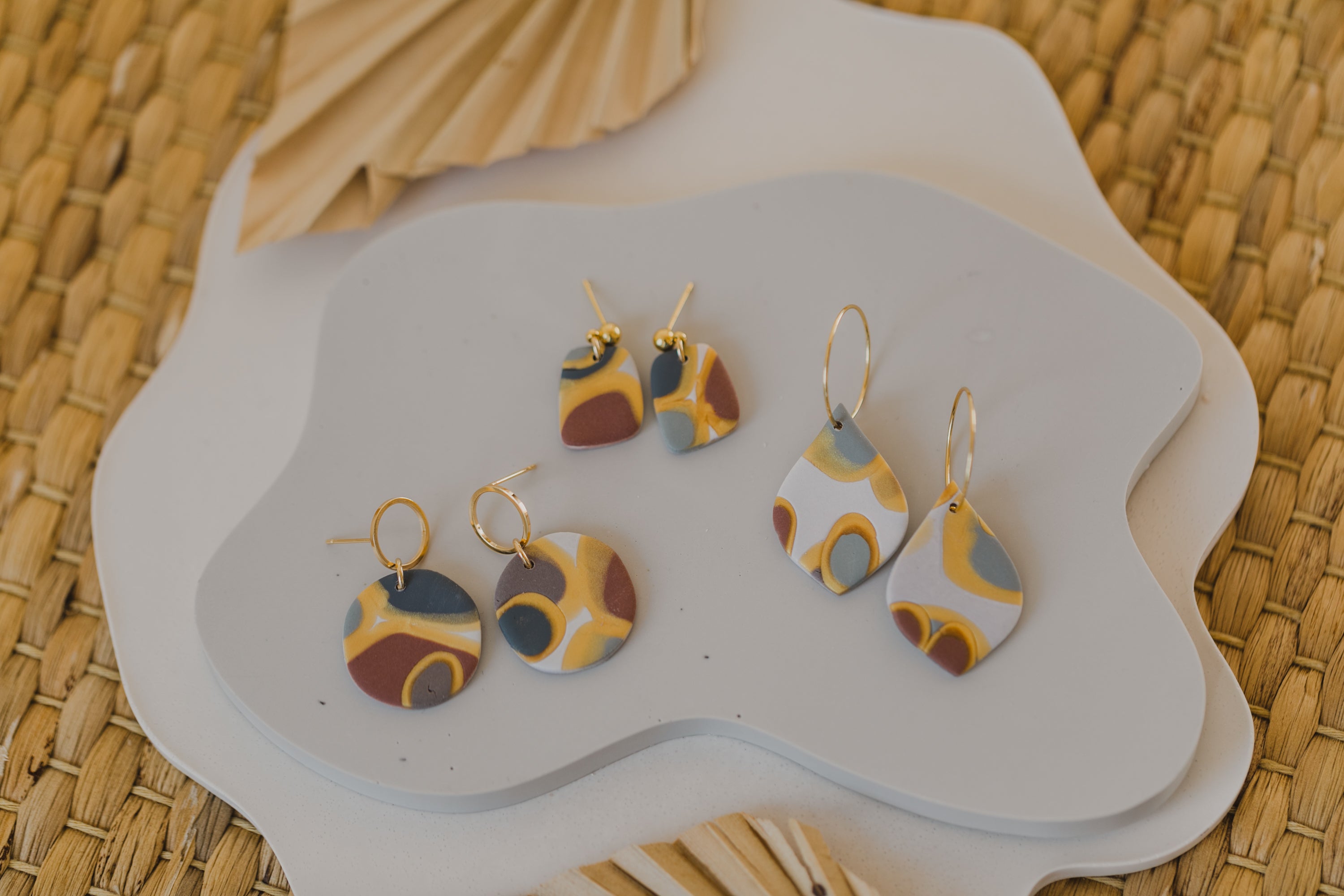 golden earrings with acrylic in white, petrol and brown