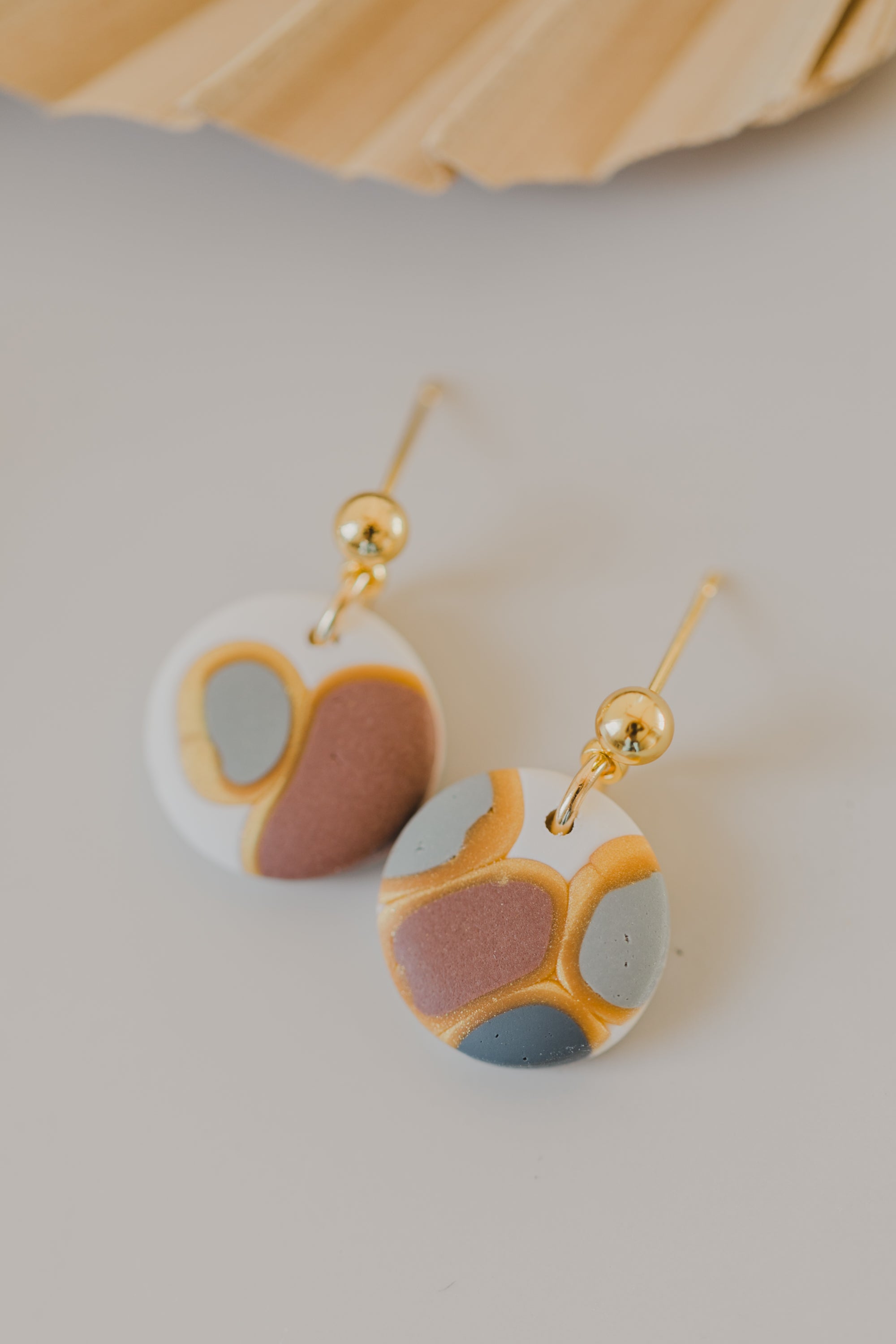 golden earrings with acrylic in white, petrol and brown