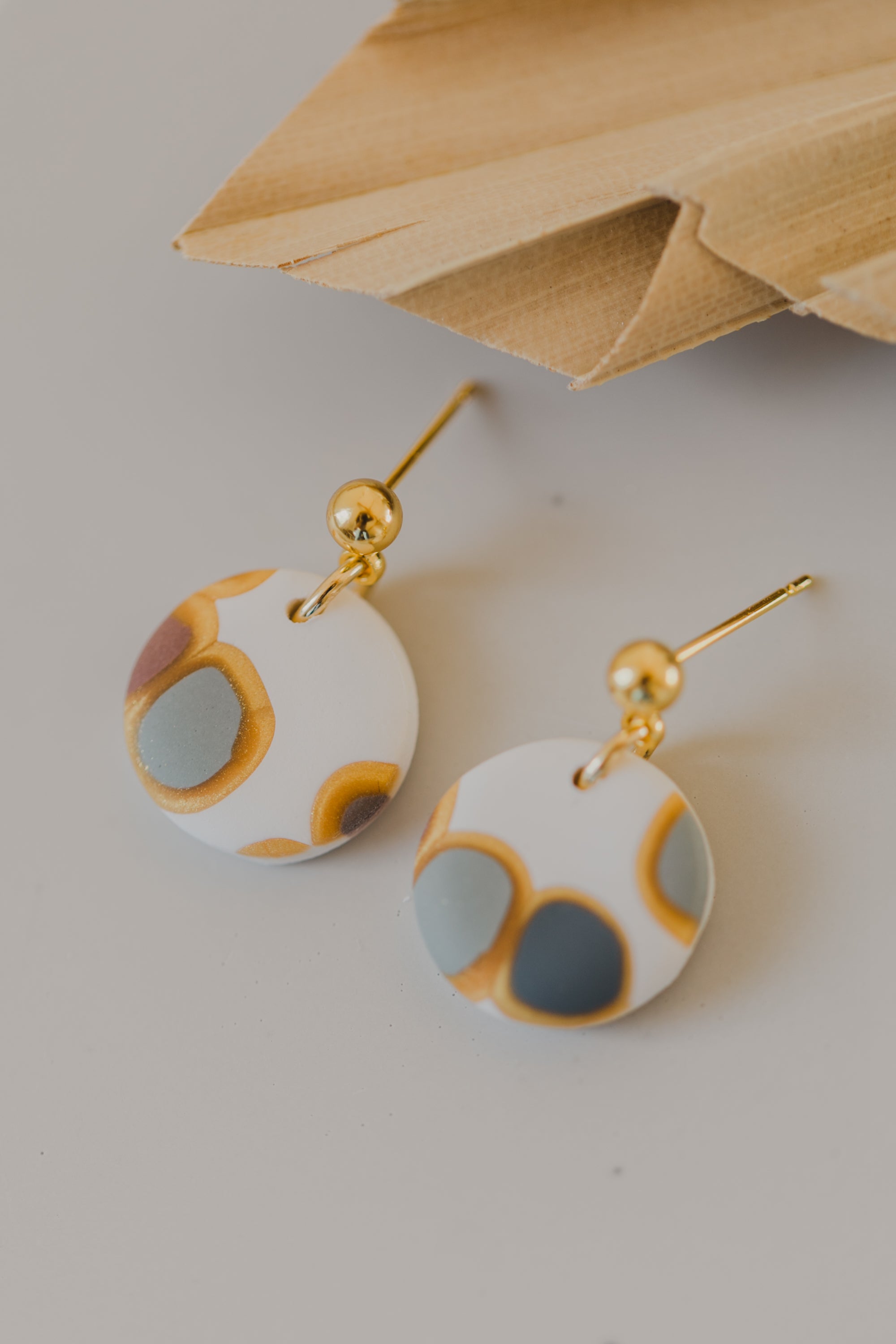 golden earrings with acrylic in white, petrol and brown