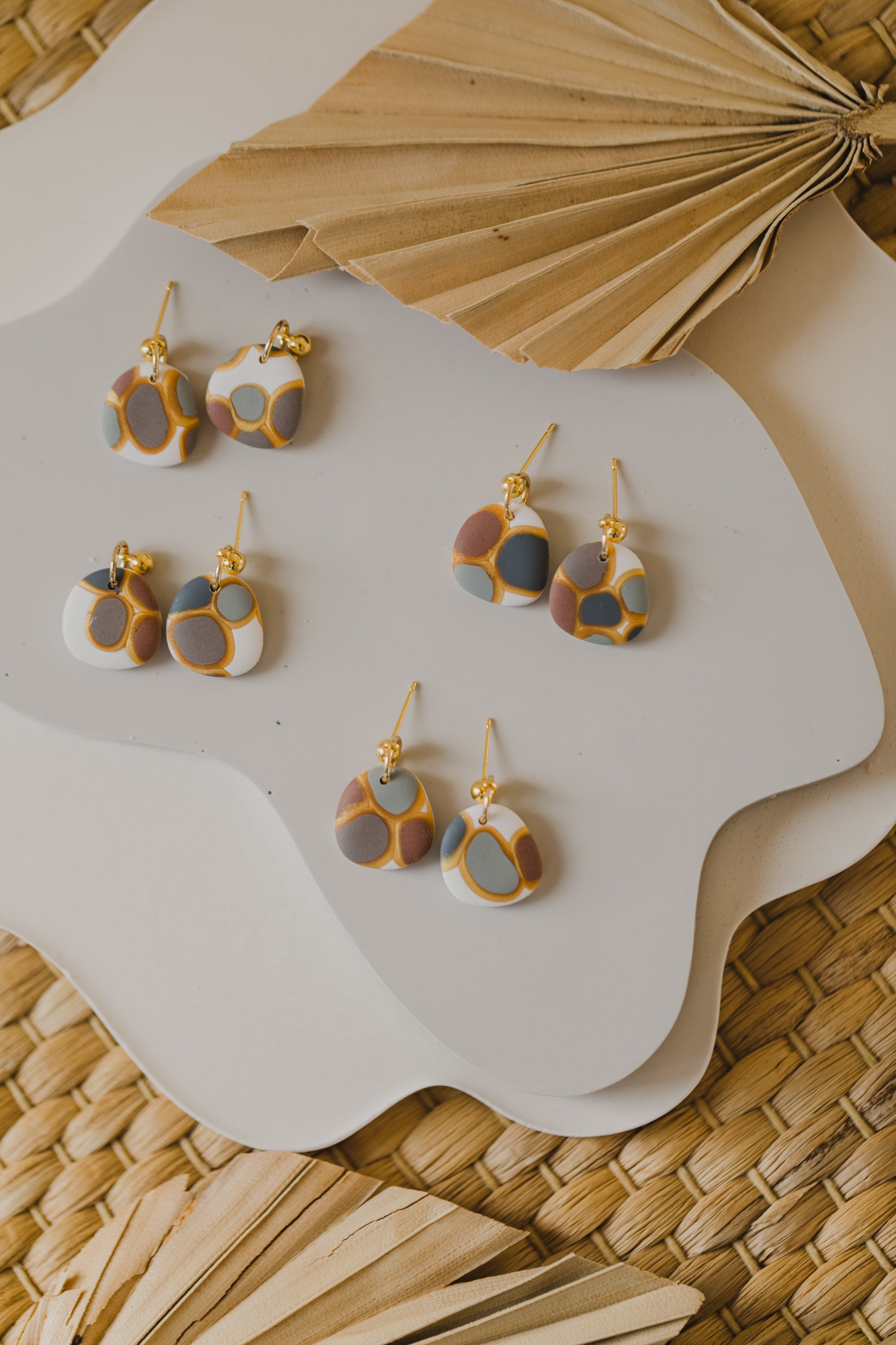 golden earrings with acrylic in white, petrol and brown