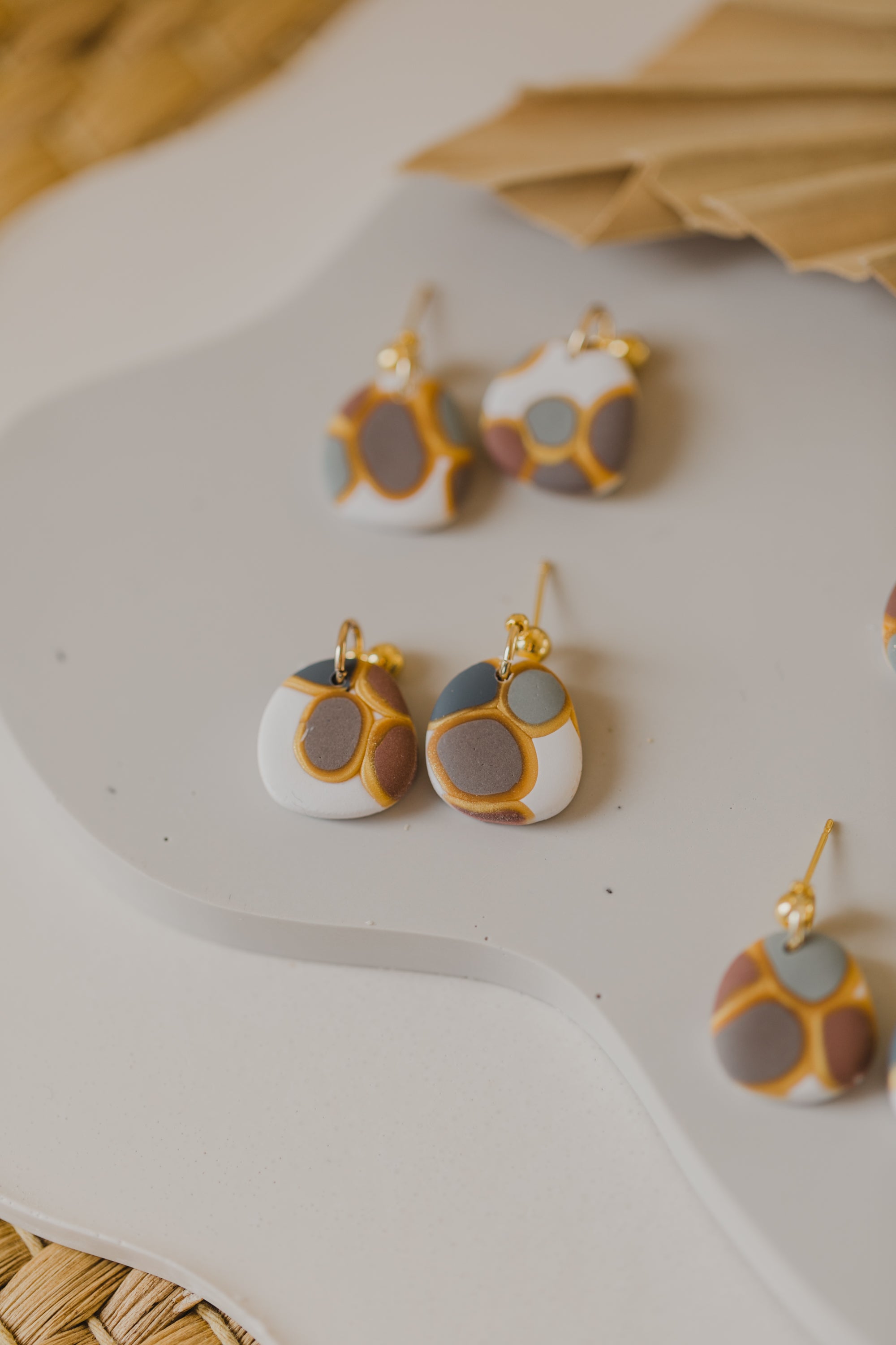 golden earrings with acrylic in white, petrol and brown