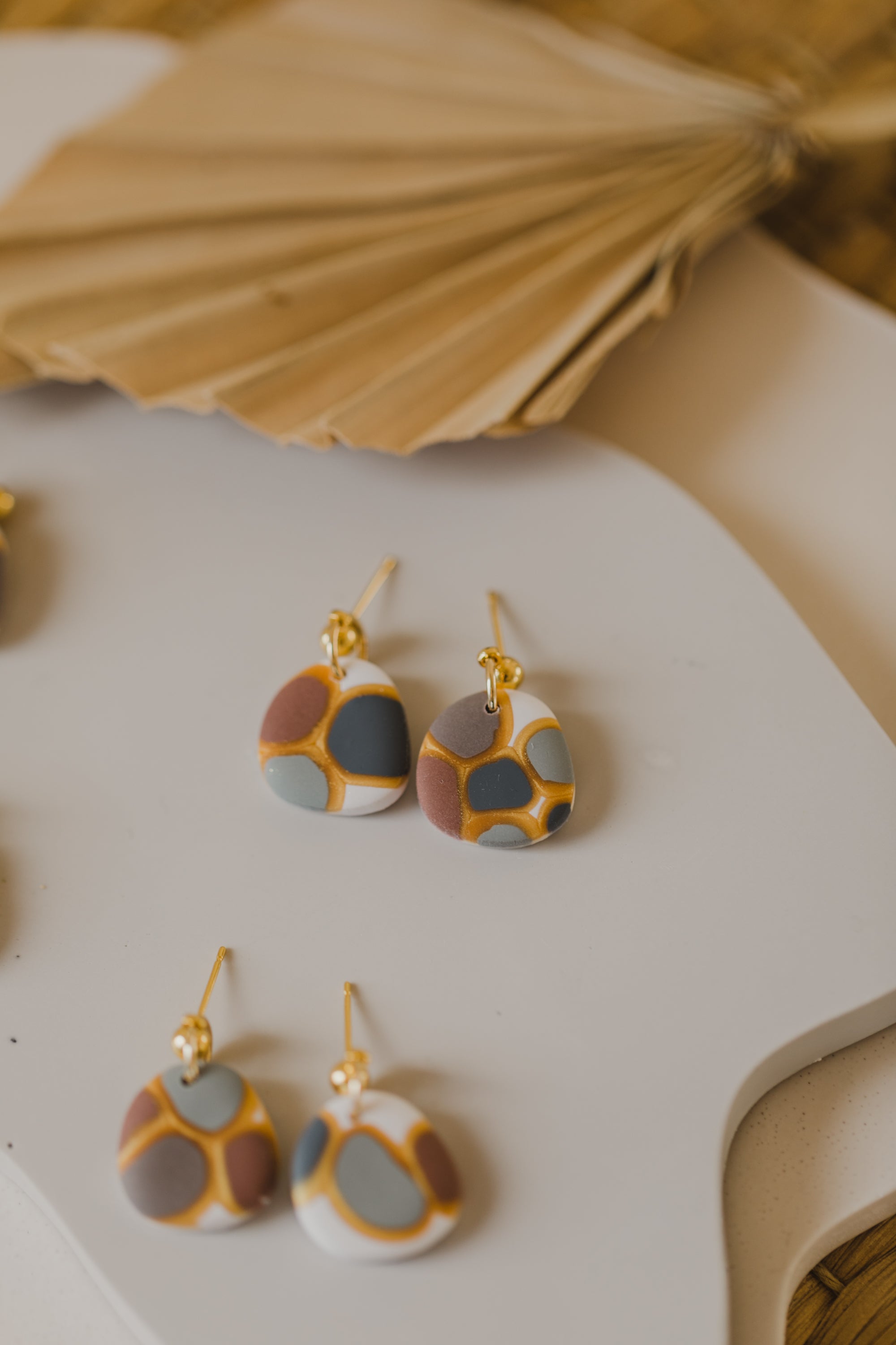 golden earrings with acrylic in white, petrol and brown