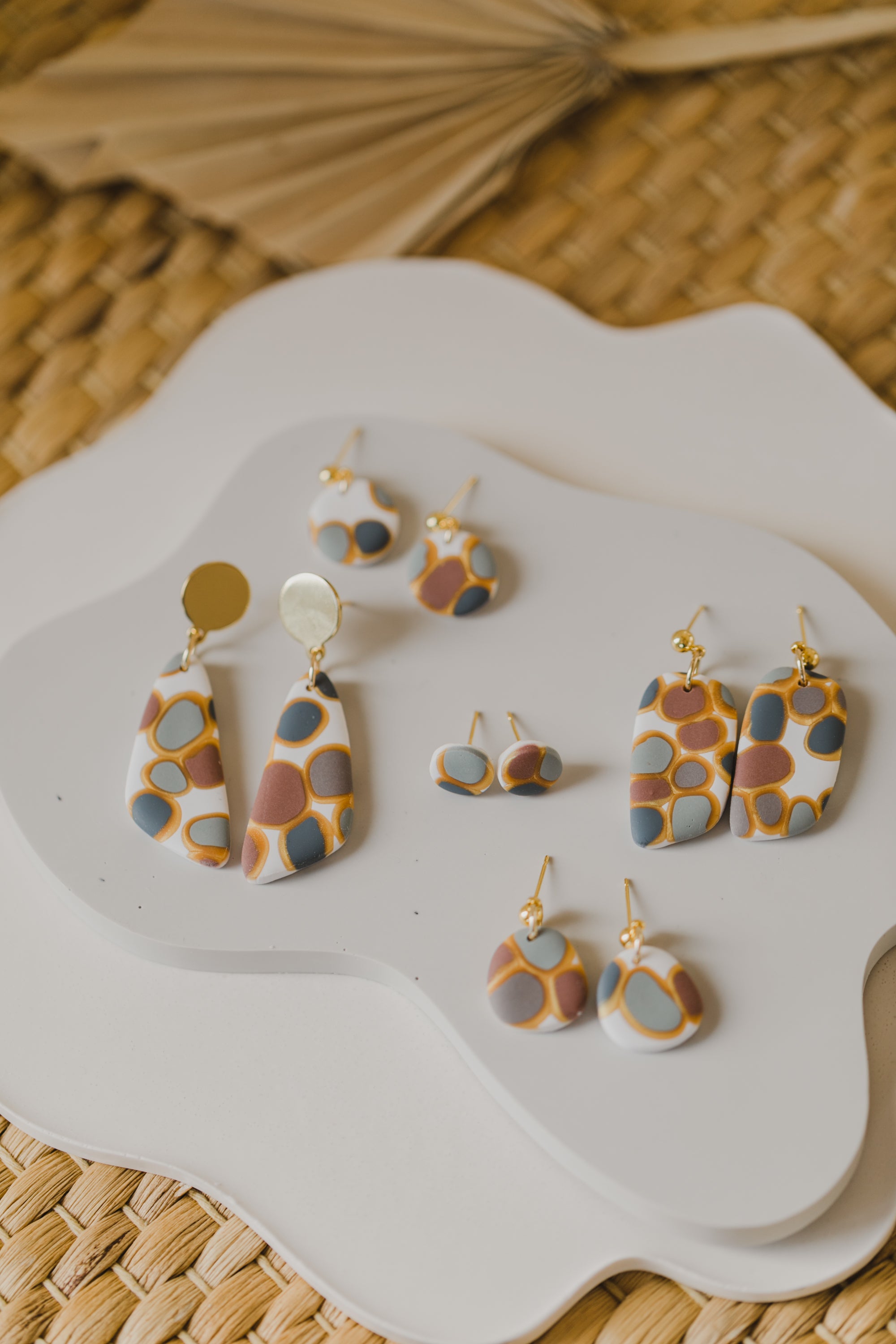 golden earrings with acrylic in white, petrol and brown