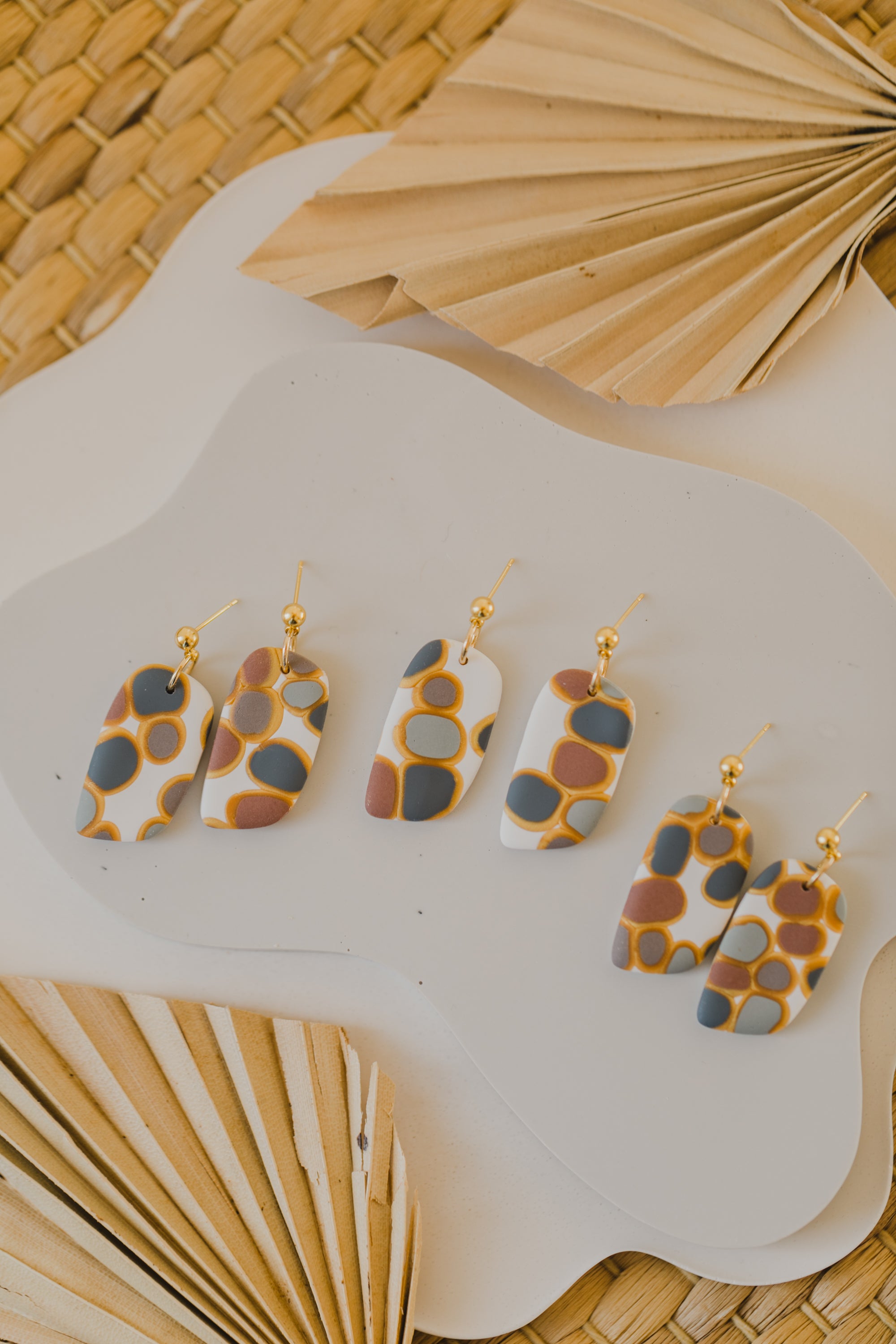 golden earrings with acrylic in white, petrol and brown