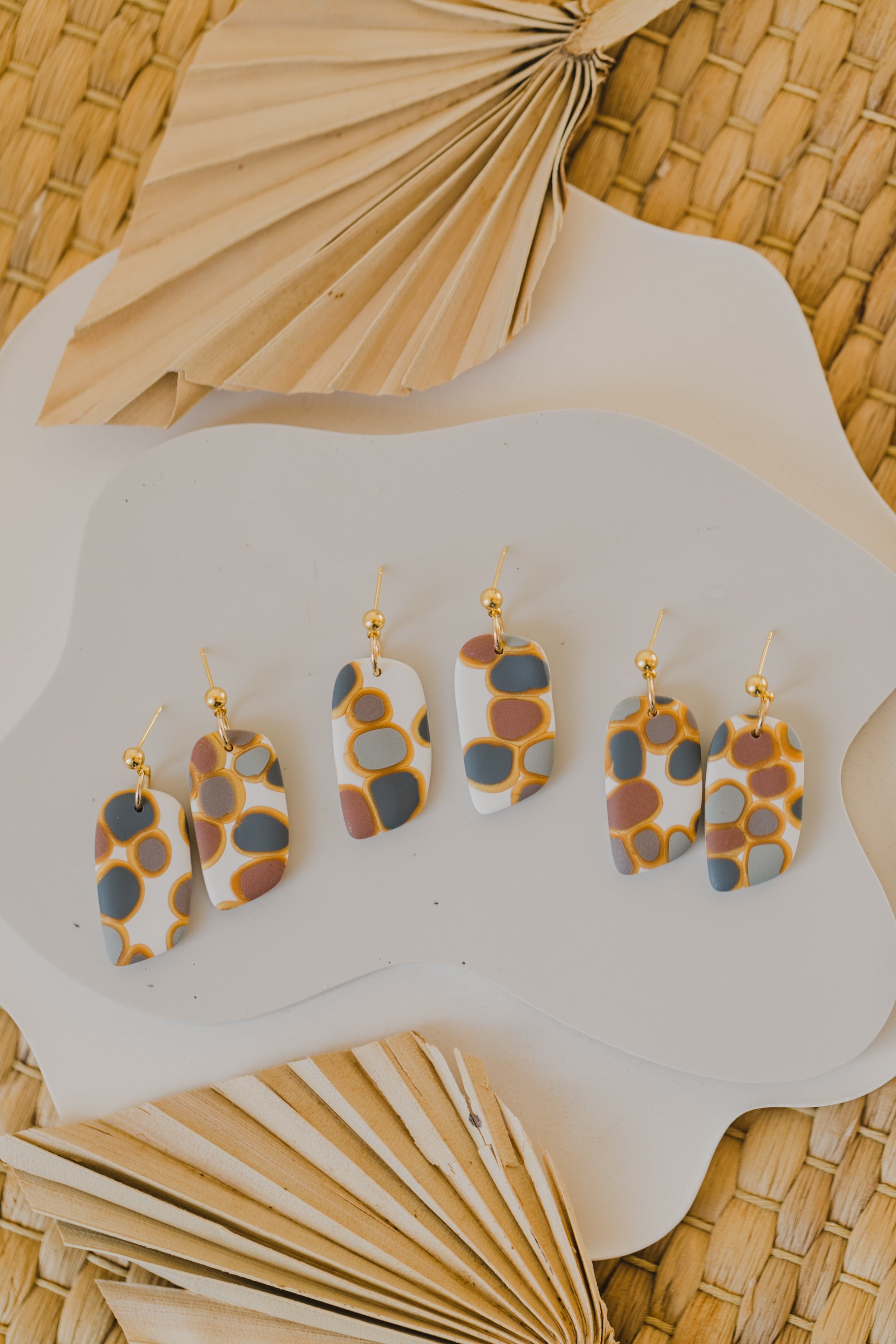 golden earrings with acrylic in white, petrol and brown