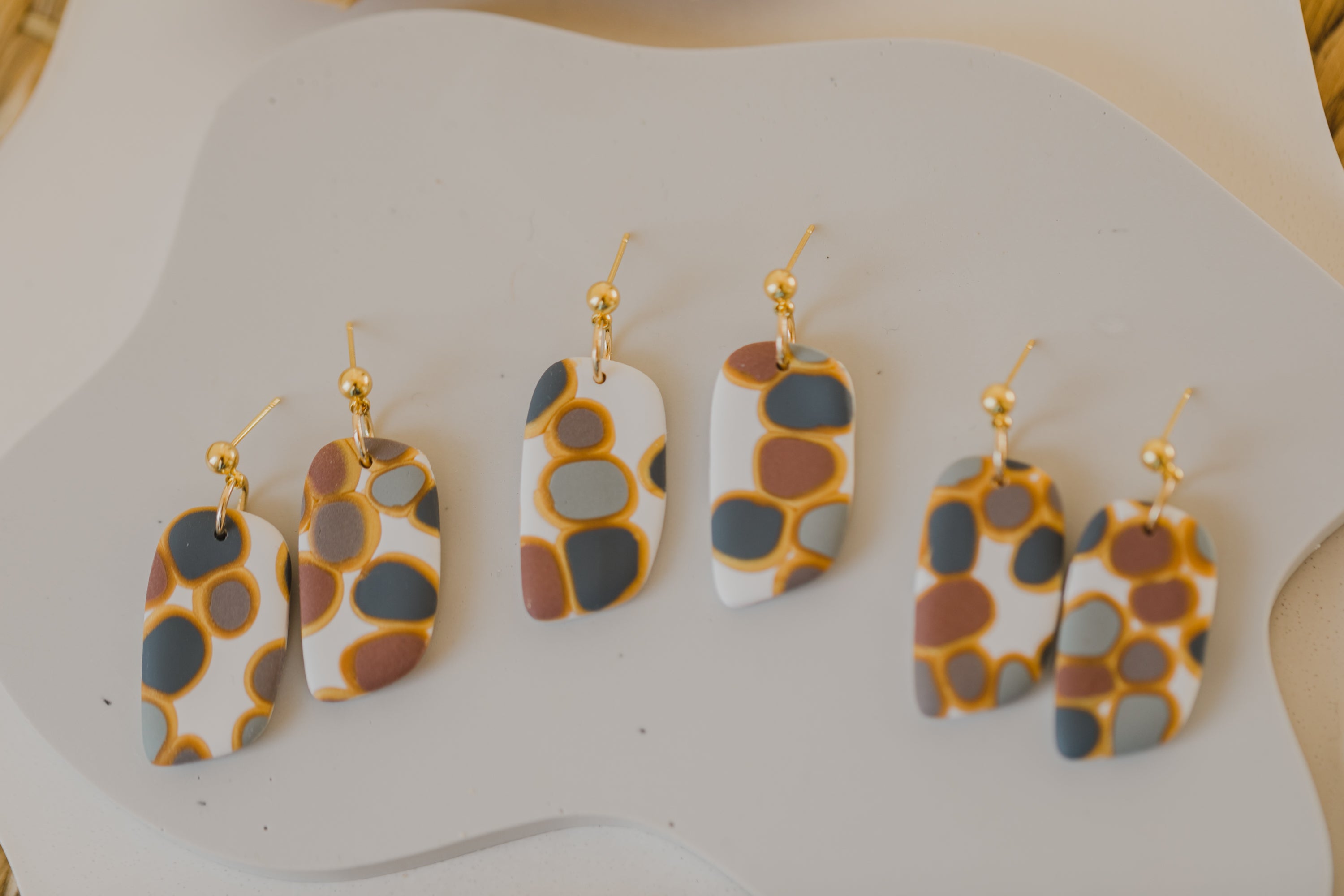 golden earrings with acrylic in white, petrol and brown
