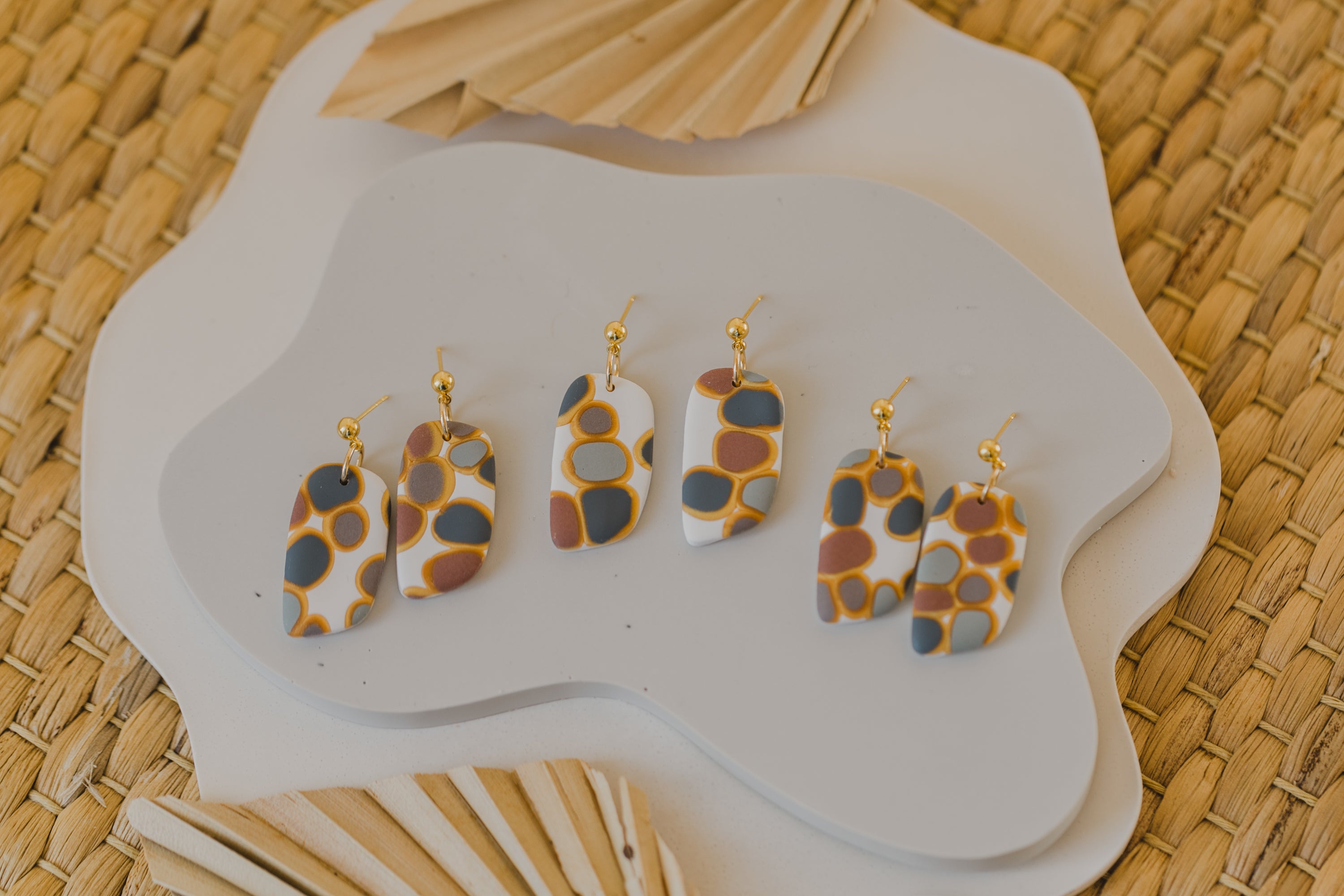 golden earrings with acrylic in white, petrol and brown