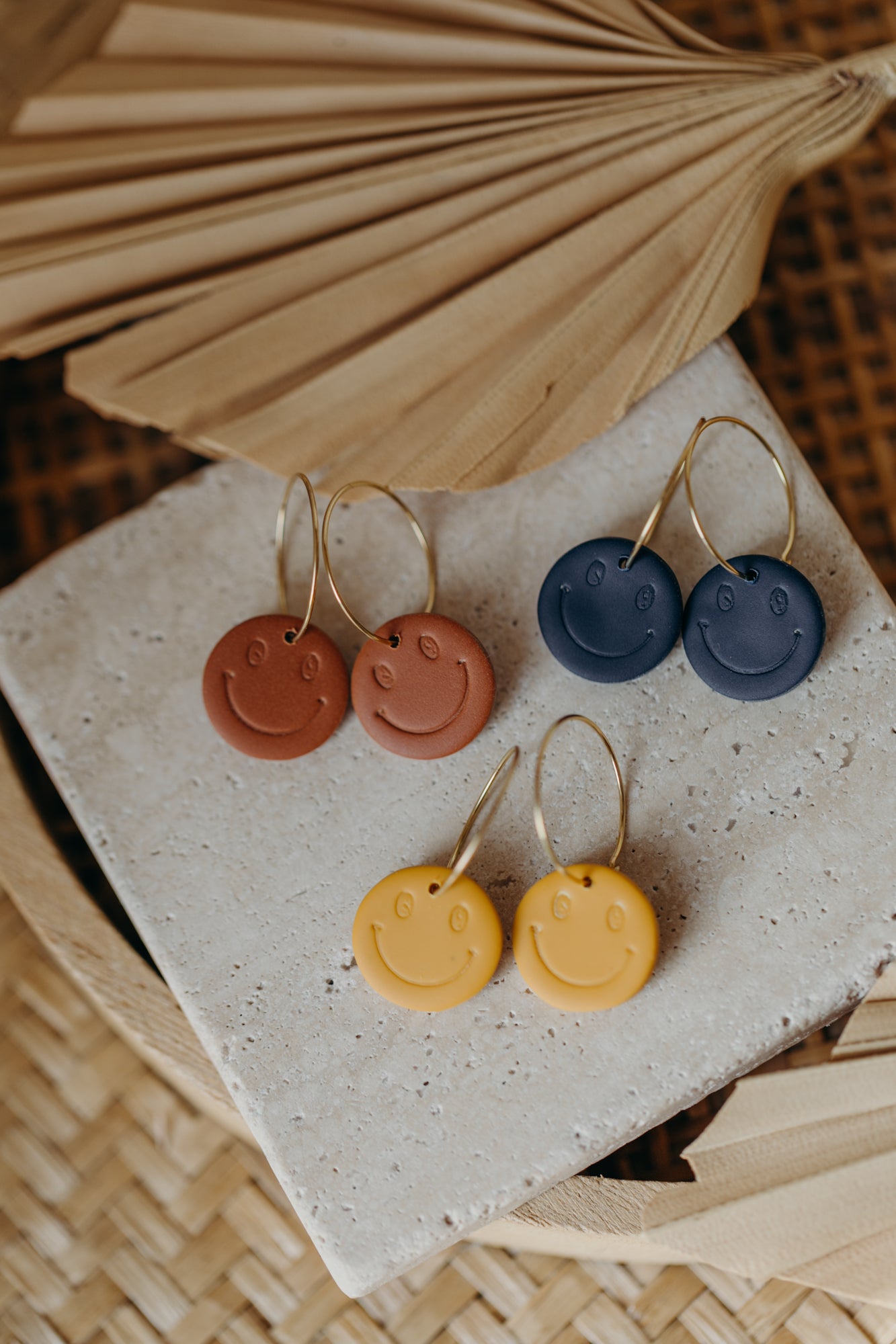 yellow smiley face hoop earrings made of polymer clay