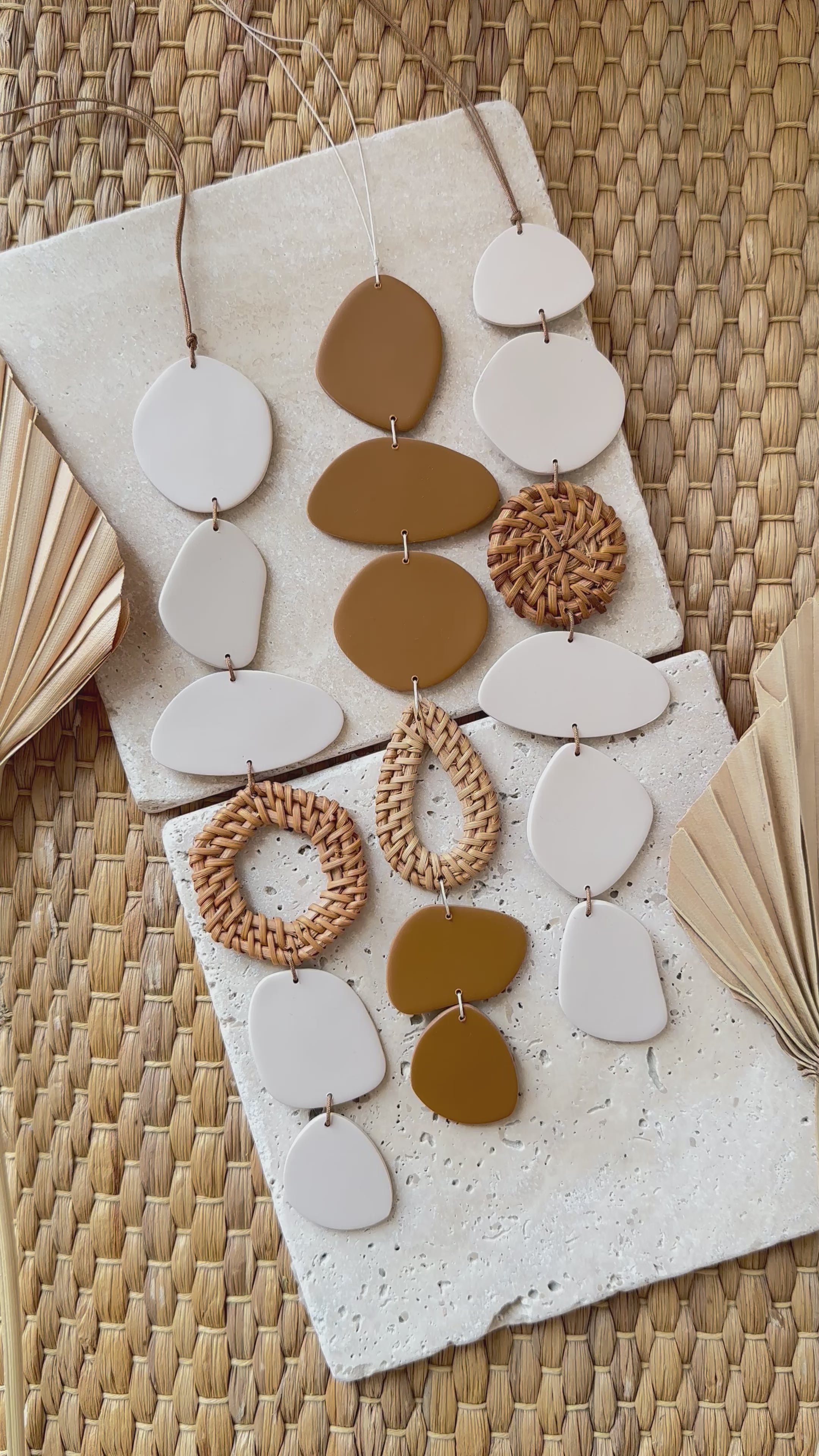 Wall mobile made of polymer clay in cream color with rattan elements