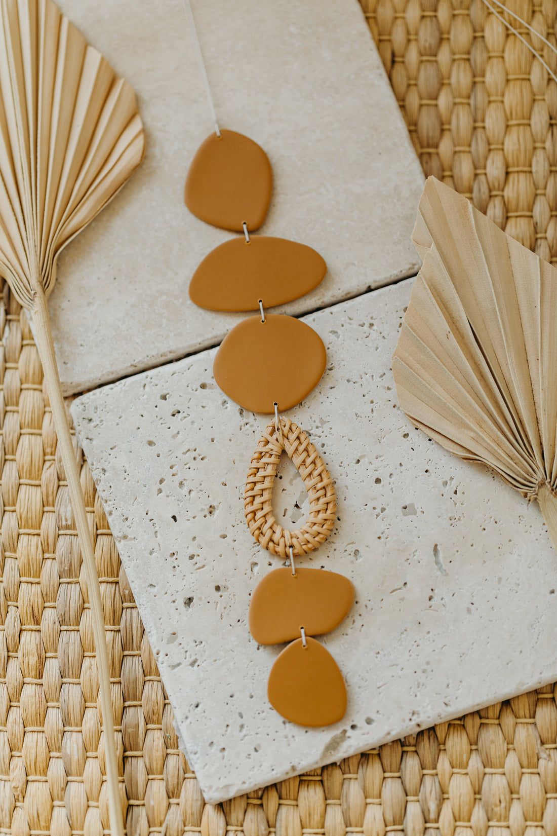 Wall mobile made of polymer clay in natural colors and rattan elements