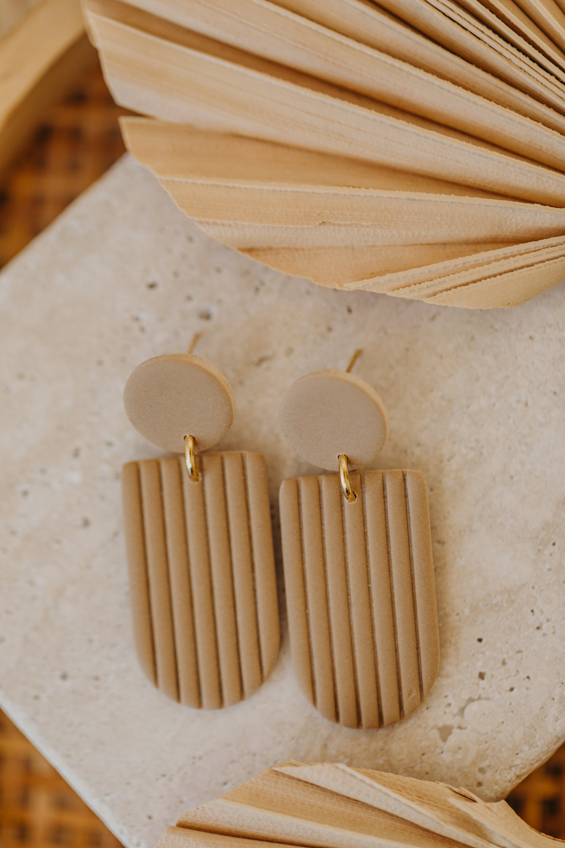 MOEMI - striped sand-colored earrings in a bow shape