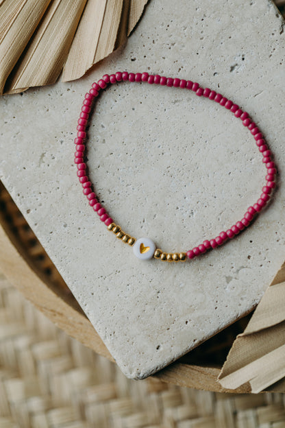 weiß-goldenes Herz Perlenarmband in himbeere