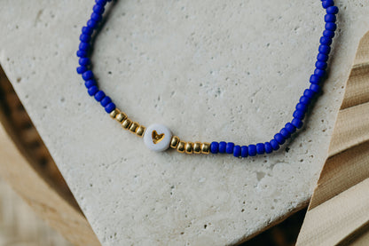 weiß-goldenes Herz Perlenarmband in kornblumenblau