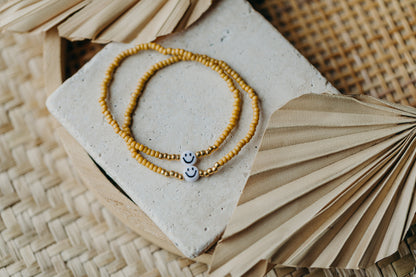 Smiley Perlenarmband in senfgelb