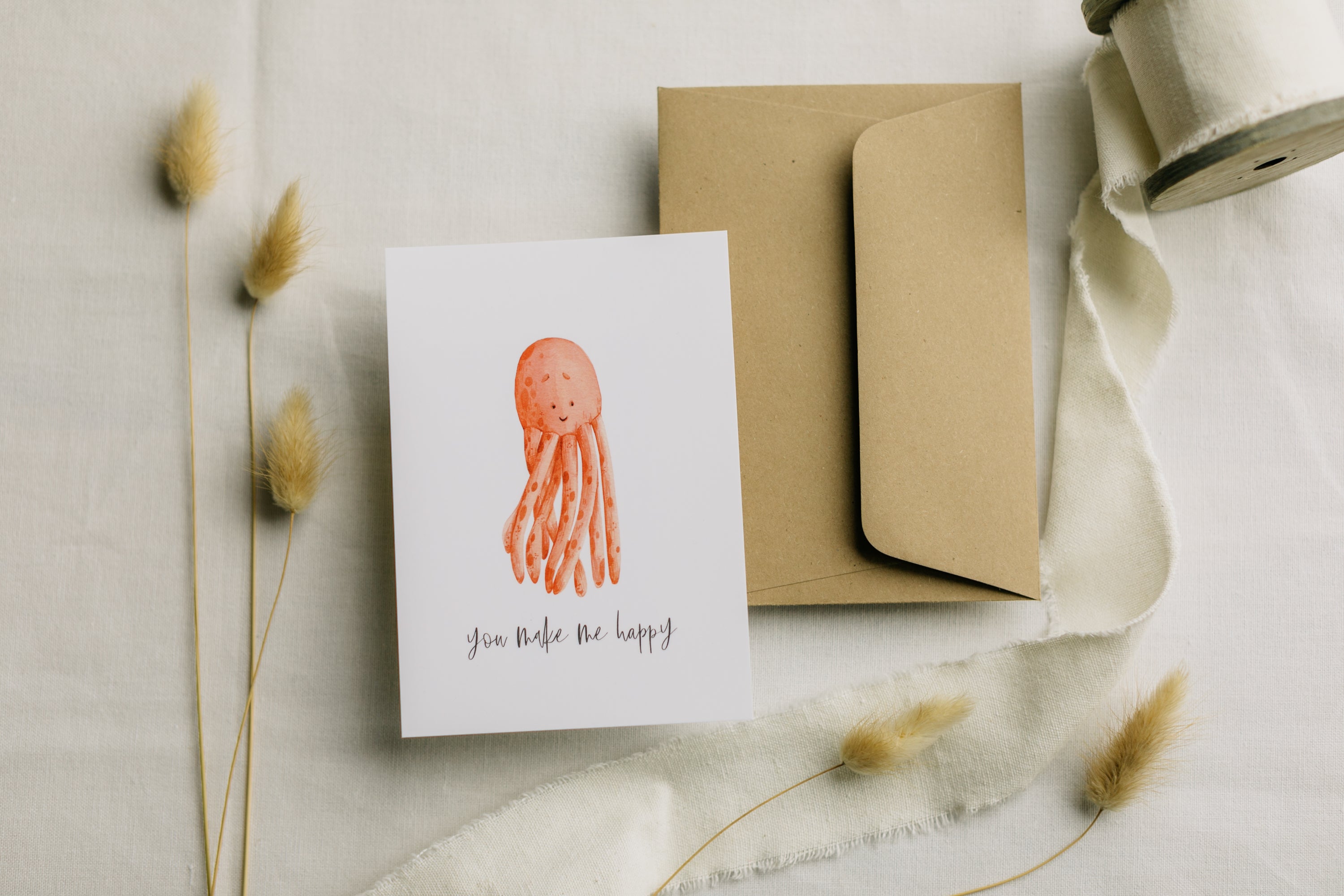 Postkarte roter Oktopus mit dem Aufdruck &quot;you make me happy&quot;
