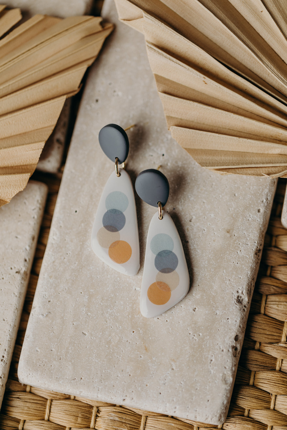 elongated blue-grey polymer clay earrings with blue and orange dots