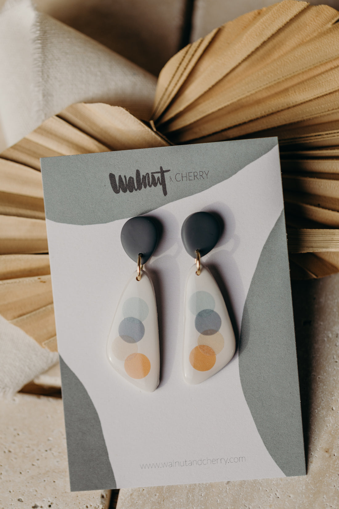 elongated blue-grey polymer clay earrings with blue and orange dots