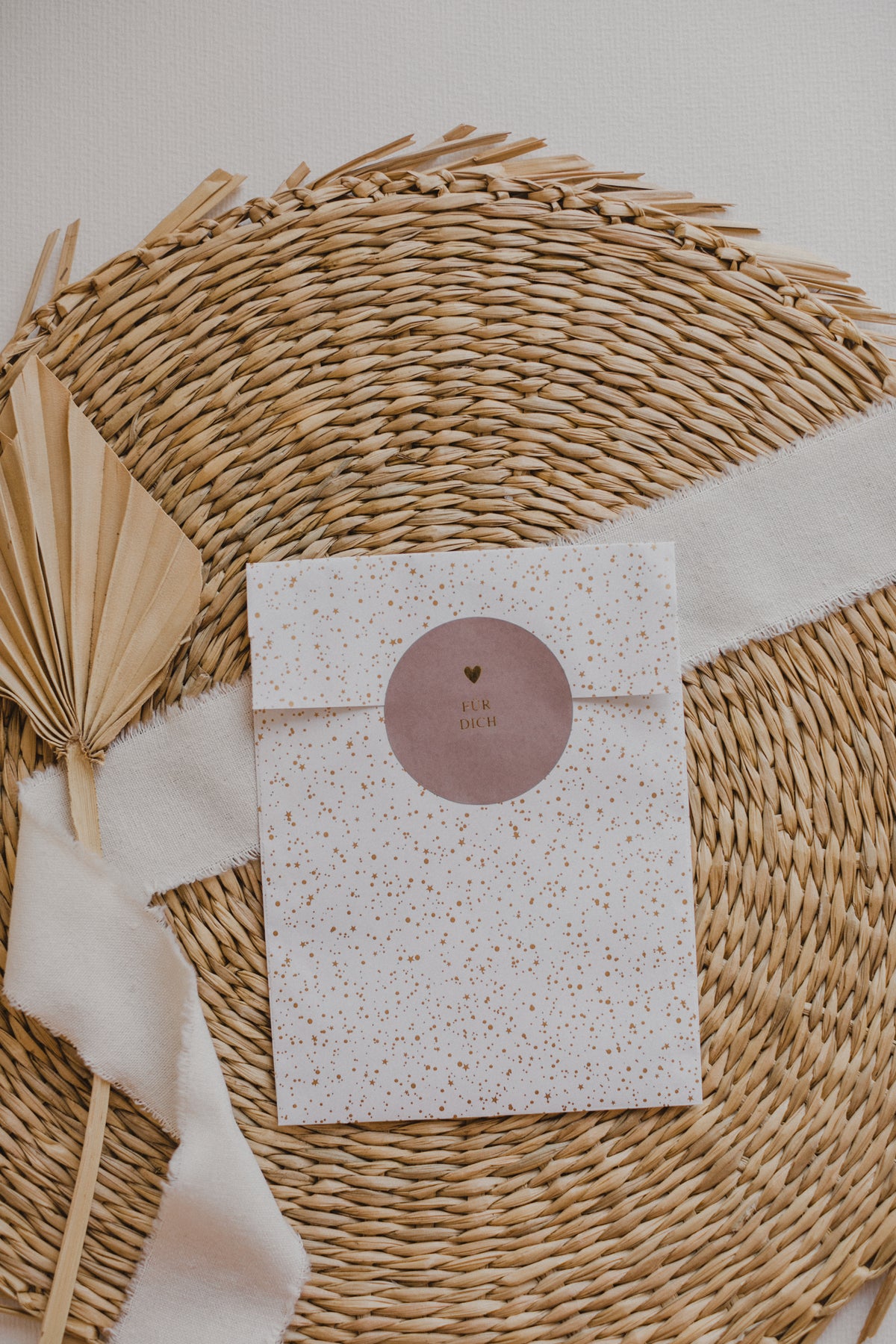 große weiße Papiertüte mit goldenen Punkten
