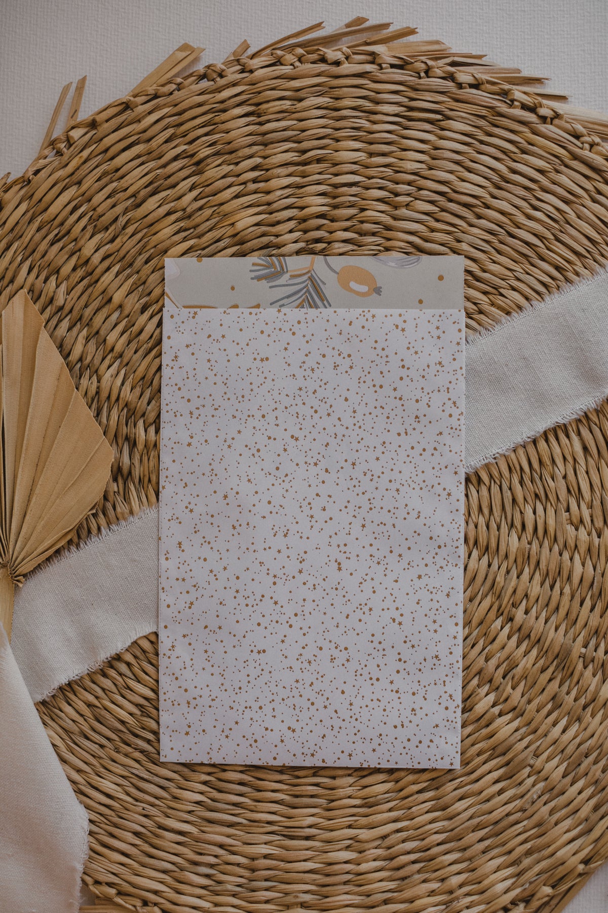 große weiße Papiertüte mit goldenen Punkten