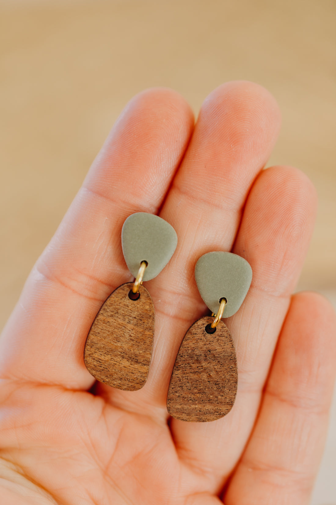 triangular polymer clay earrings in eucalyptus green with rectangular wooden pendant